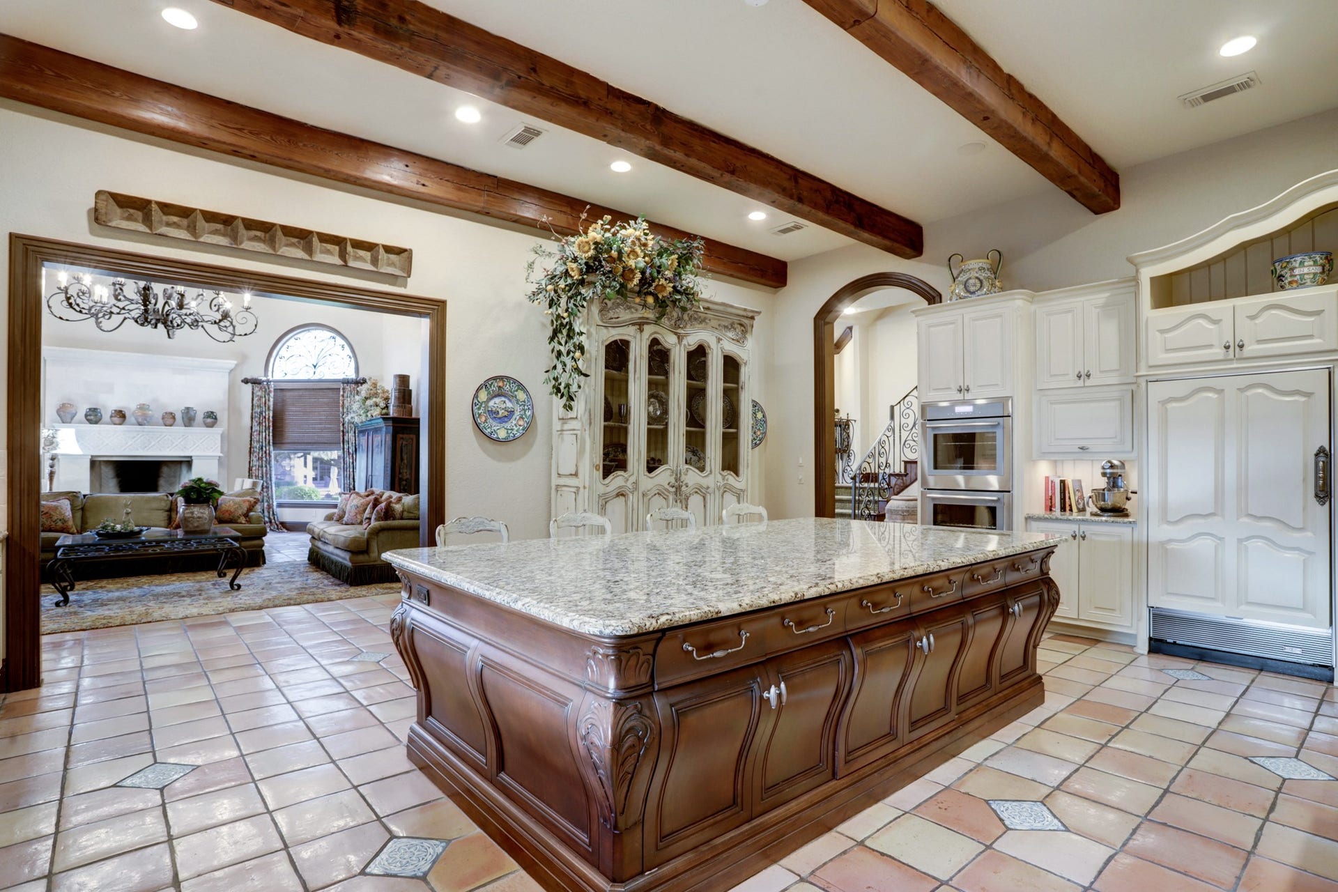 36 Saddlebrook Court, Tomball, TX 77375 The spacious kitchen boasts a 55 sq.ft. granite island, SubZero appliances, a top-tier range, vintage wood beams, custom Osborne cabinets, and antique French terra cotta tile flooring.