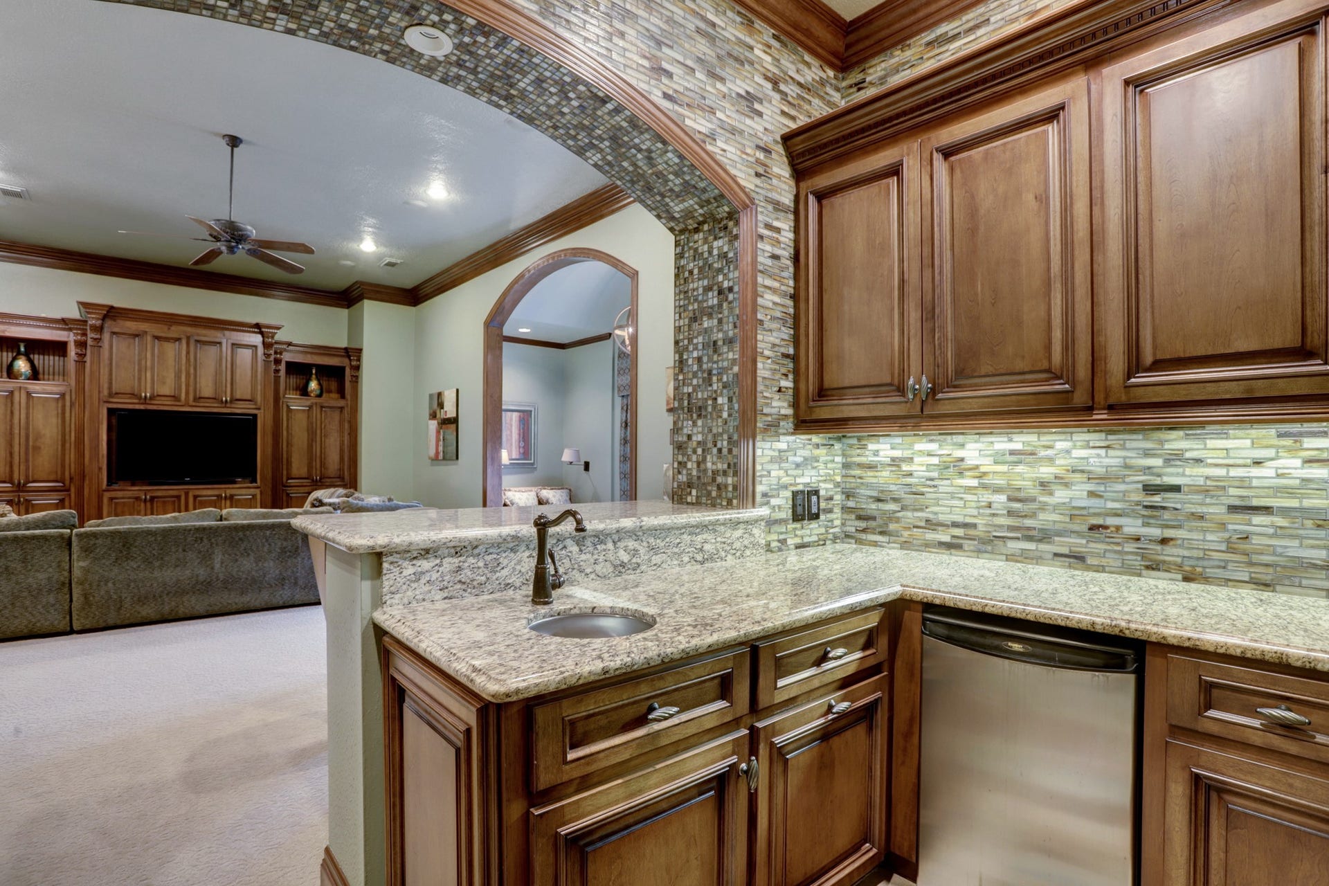 36 Saddlebrook Court, Tomball, TX 77375 Perfect for entertaining, the upstairs living area features a convenient kitchenette with granite countertops, sink, and dishwasher, complemented by a spacious open-concept design ideal for hosting gatherings.