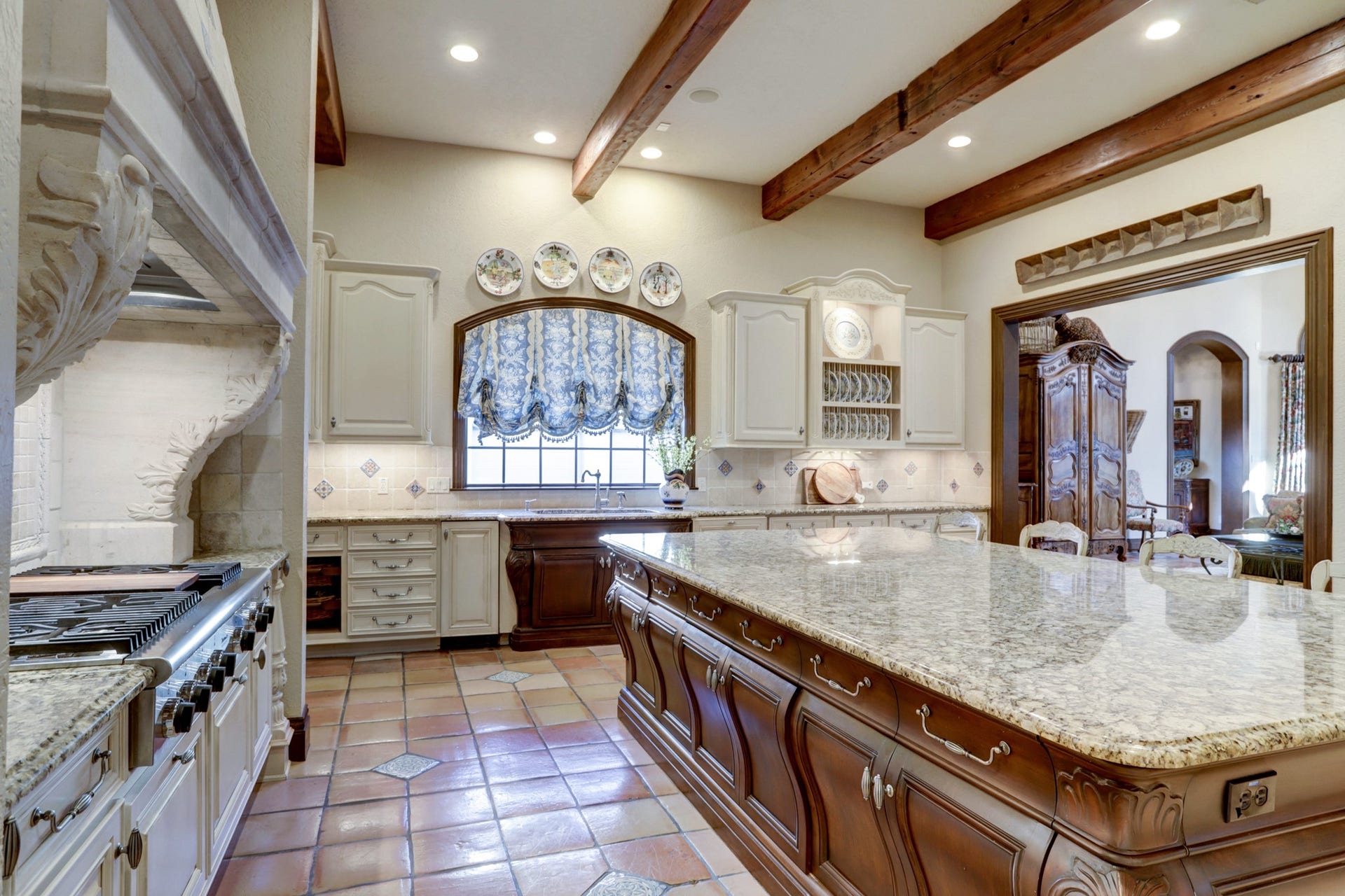 36 Saddlebrook Court, Tomball, TX 77375 The chef's kitchen, graced with intricate French design, bombay custom cabinetry which offers a spacious 55 sq.ft. granite island, seamlessly transitioning into the den perfect for entertaining everyone.