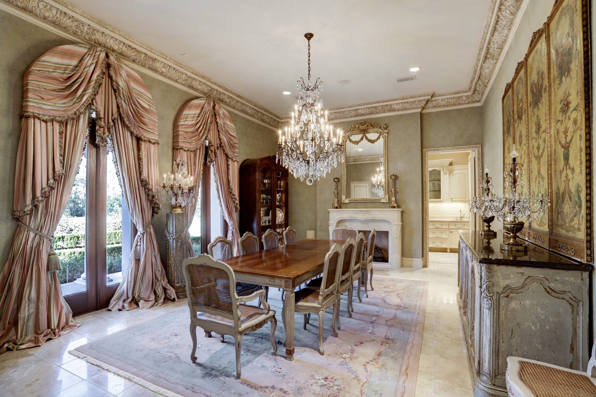 36 Saddlebrook Court, Tomball, TX 77375 Exuding old-world French charm, the formal dining area epitomizes elegance with lavish crown molding, marble floors, crystal chandelier, and a fireplace, elevating the dining experience to unparalleled heights.