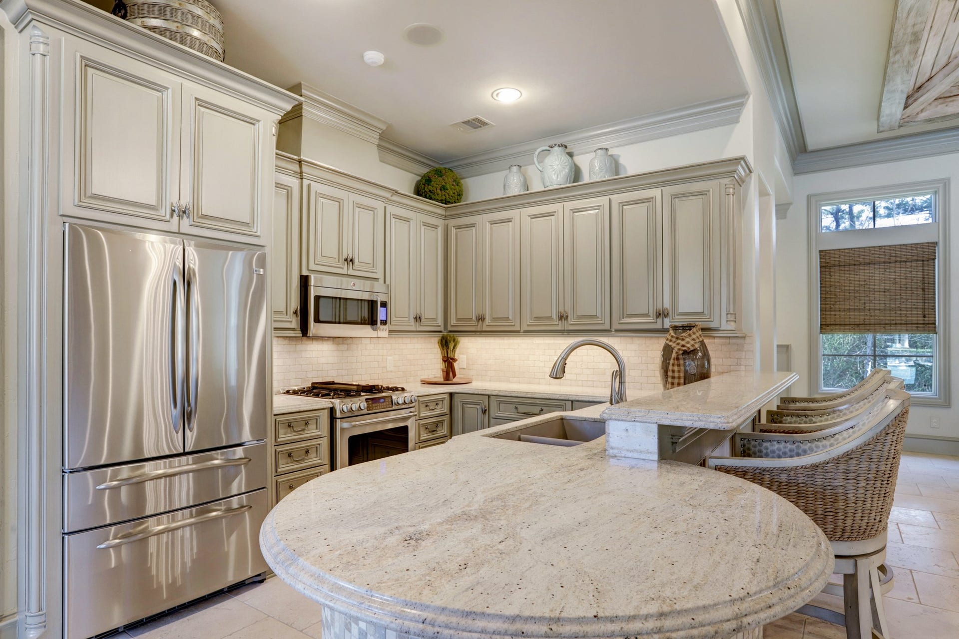 36 Saddlebrook Court, Tomball, TX 77375 Pool house boasts a full kitchen flooded with natural light, showcasing timeless granite countertops, GE Cafe stainless steel appliances, and bar seating for added convenience.