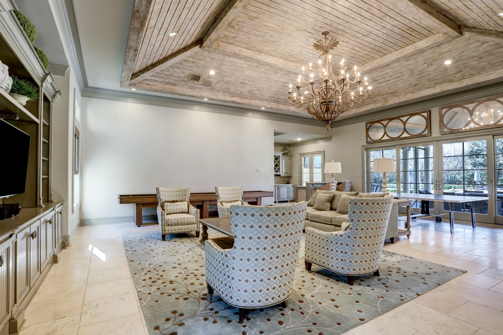36 Saddlebrook Court, Tomball, TX 77375 Flooded with natural light, the pool house features elegant travertine flooring, a built-in entertainment wall, and exquisite millwork on the ceiling and creates a seamless transition between the indoor and outdoor living spaces.