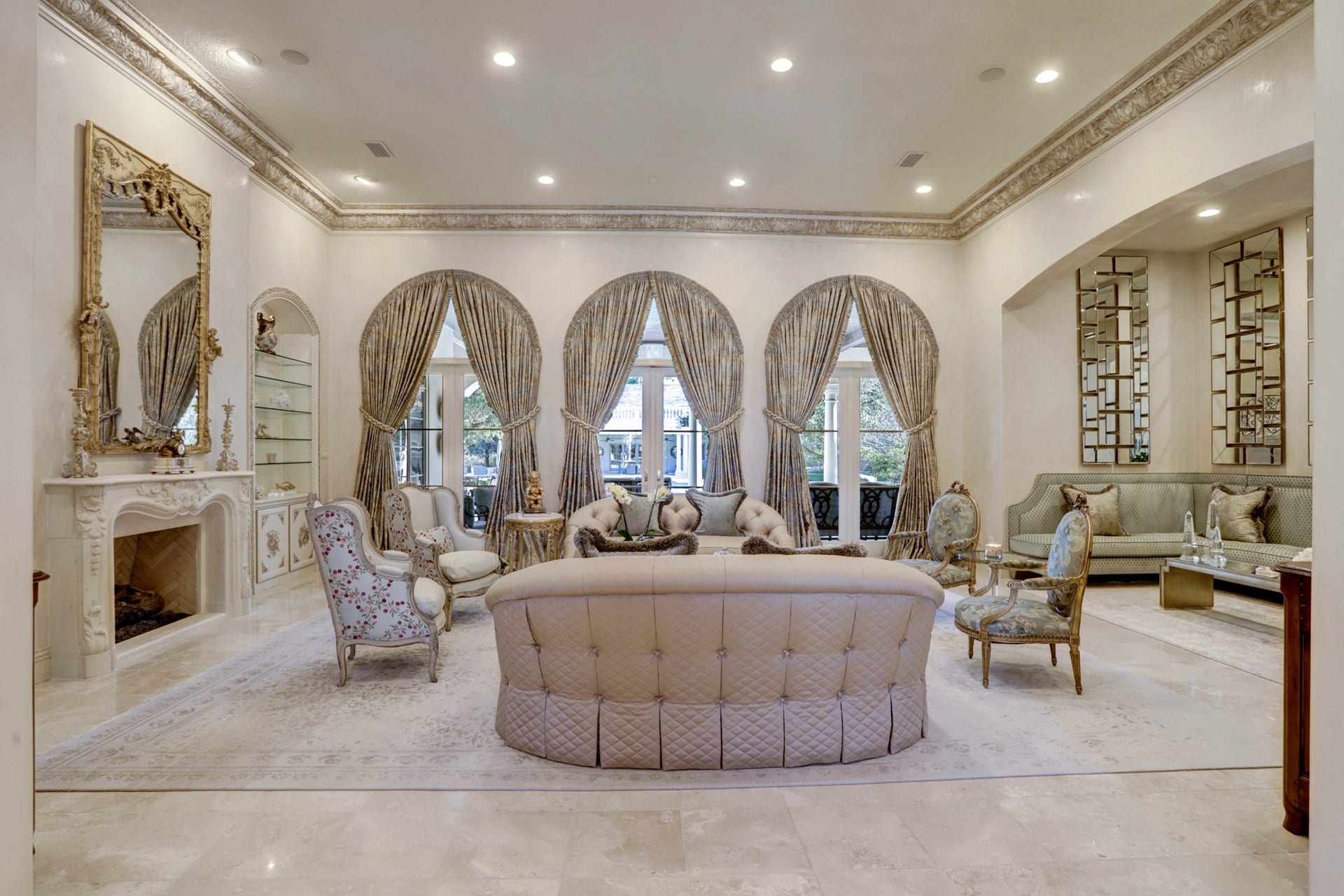 36 Saddlebrook Court, Tomball, TX 77375 Formal living room boasts unparalleled luxury with its decadent marble, meticulously crafted intricate crown molding, and a fireplace that adds an aura of refined elegance and sophistication.