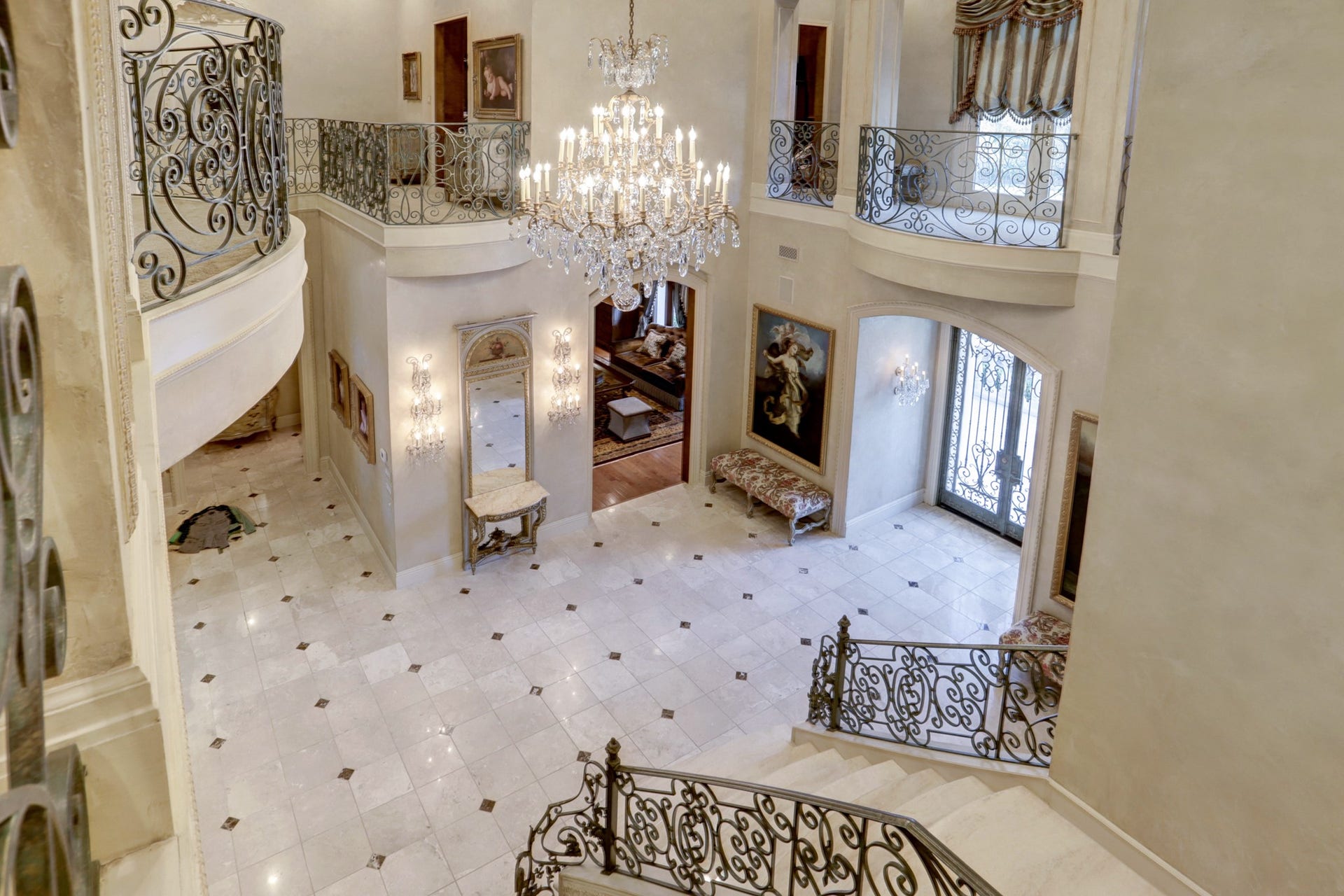 36 Saddlebrook Court, Tomball, TX 77375 View from above foyer showcases the gleaming marble floors and 18th Century Venetian plaster technique on walls and trim and hand-crafted stair railing and balconies.