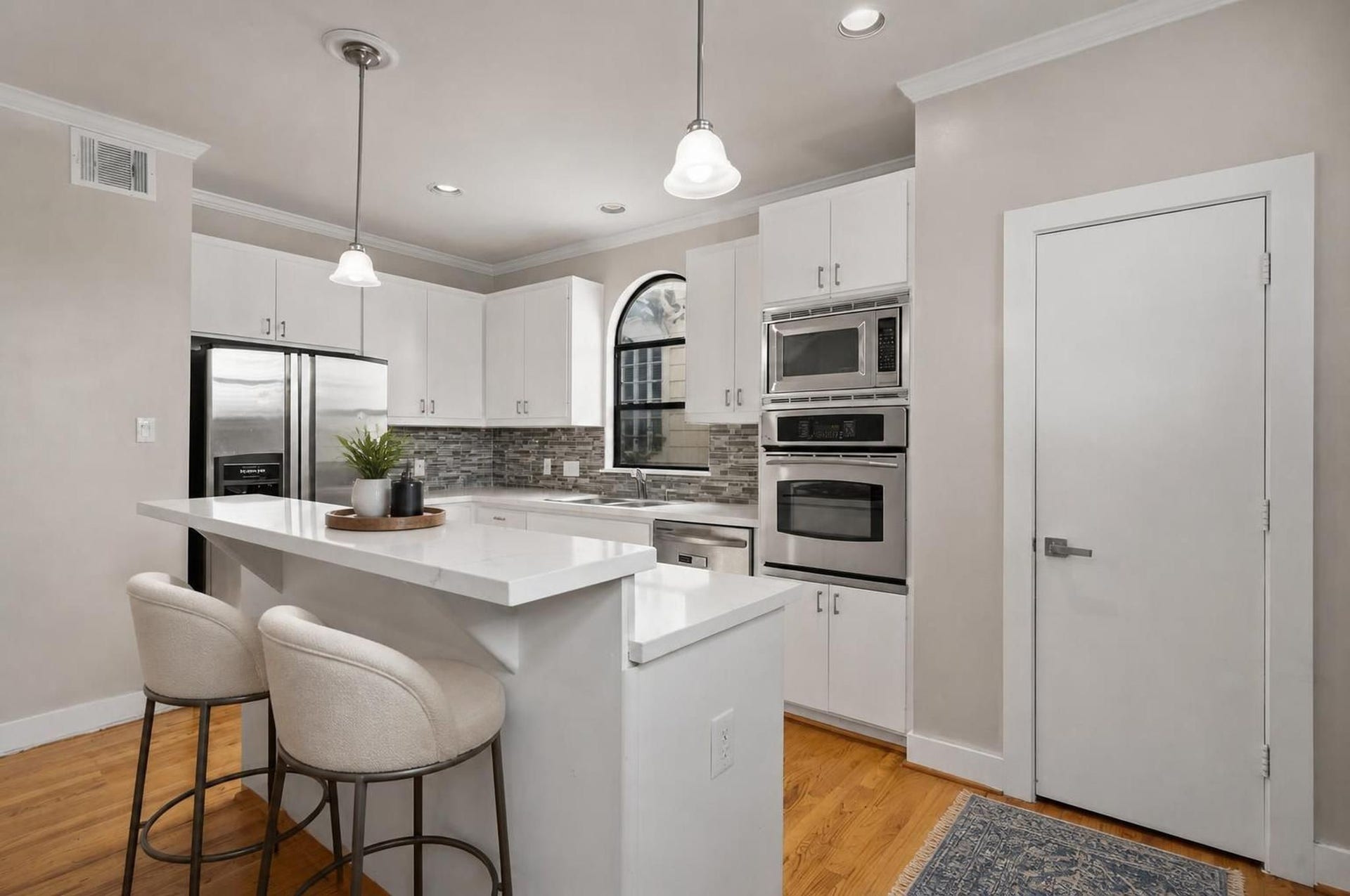 2154 Arabelle Street, Houston, TX 77007 The kitchen brings a crisp, modern feel to the center of the home with quartz countertops, a breakfast bar, and an island with cooktop. Its open placement keeps the space connected to both dining and living. Virtually staged.