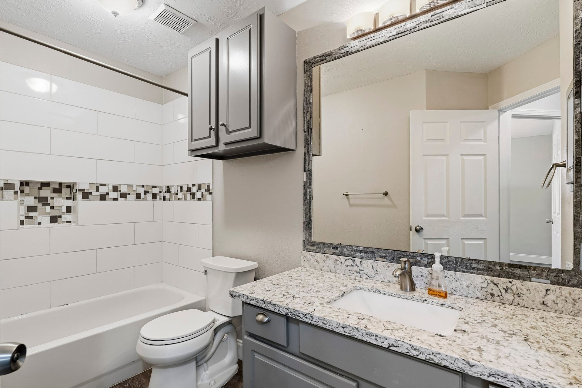 Well-appointed secondary bathroom with a tub/shower combination and vanity storage.