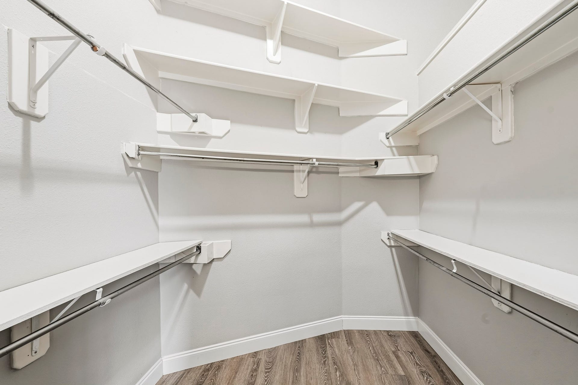 Spacious walk-in closet with built-in shelving and plenty of storage possibilities.