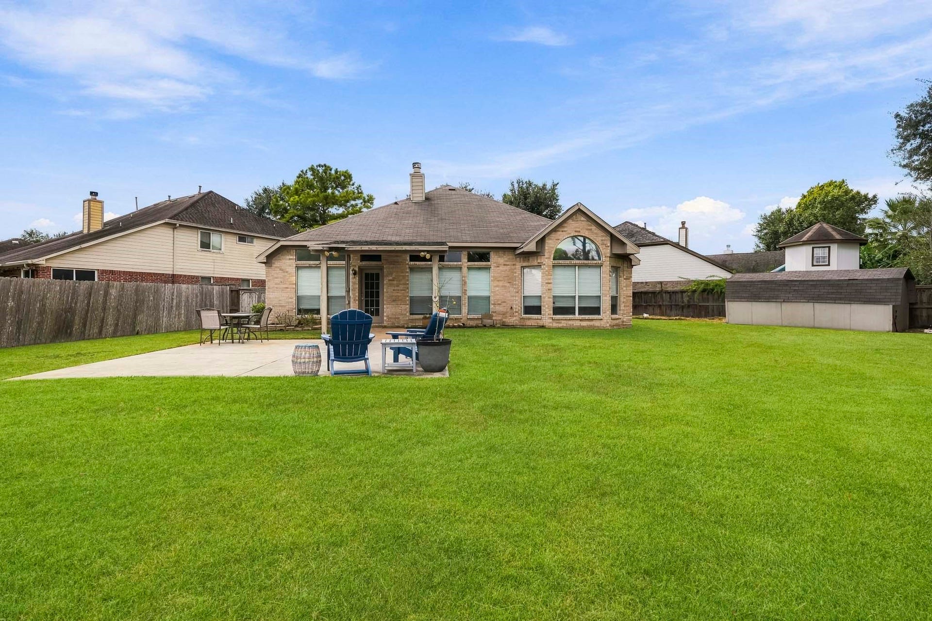Enjoy outdoor gatherings under the covered patio, with additional concrete space for entertaining.