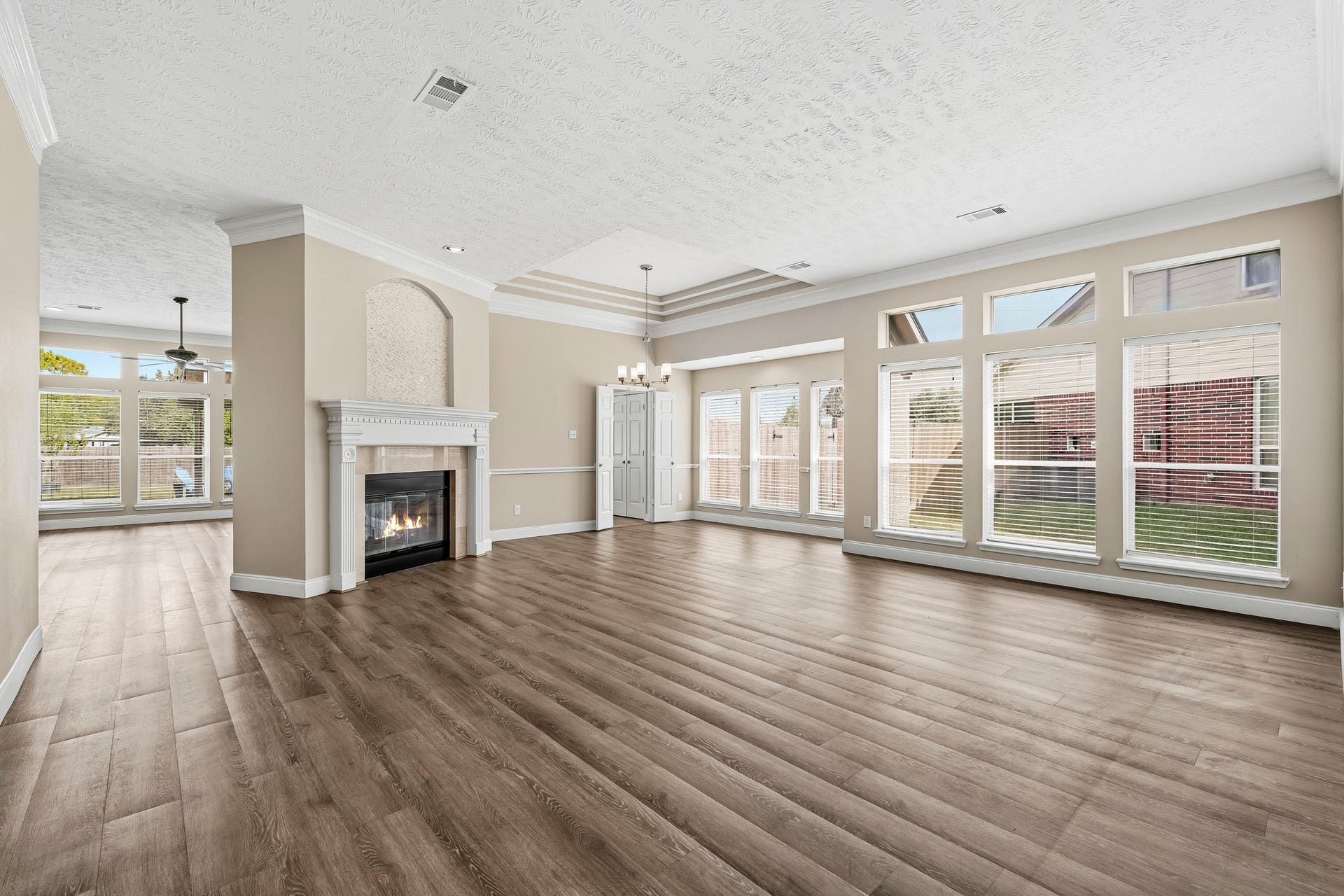 An impressive, open living and dining space with abundant natural light and a double-sided gas-log fireplace.