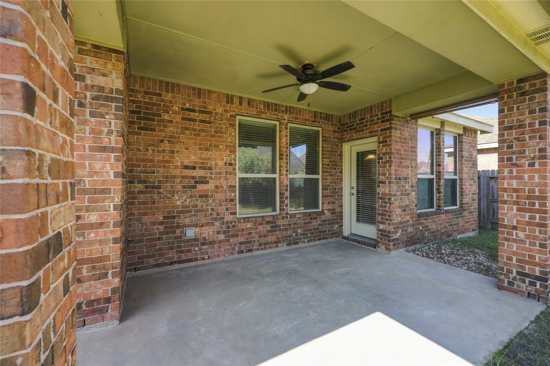 This spacious covered back patio features a ceiling fan for added comfort and plenty of room to relax, entertain, and enjoy the outdoors year round!