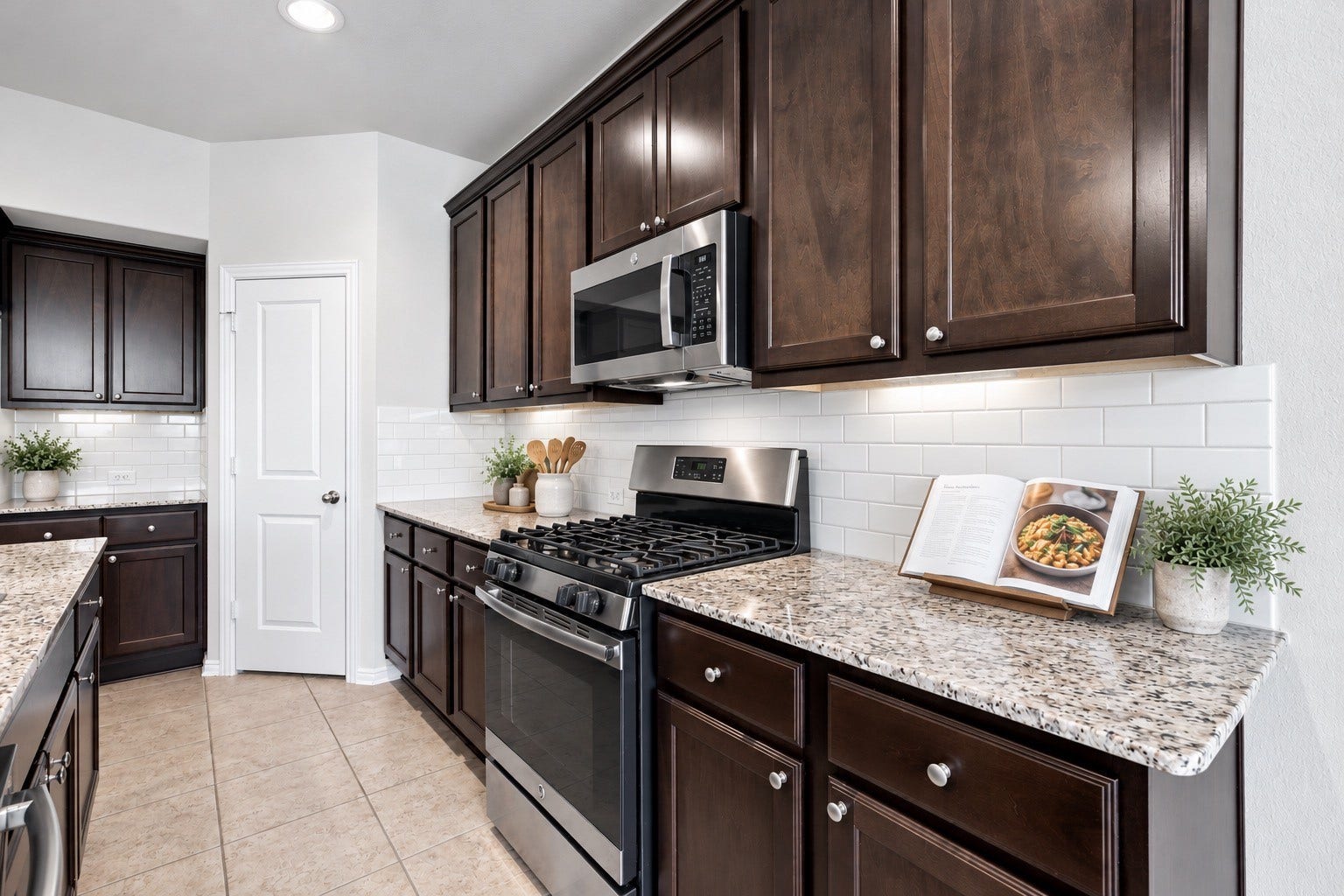 This inviting kitchen features rich dark cabinetry, beautiful granite countertops, and a classic tile backsplash.
*Virtually staged.*