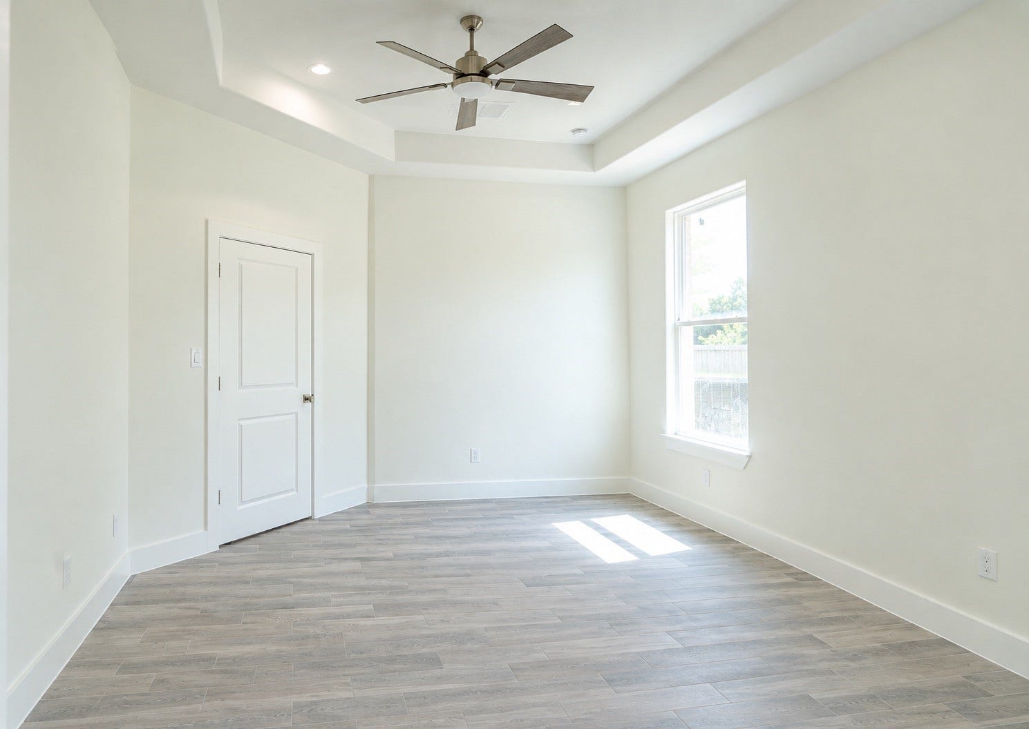 2306 Ridgewood Drive Drive, West Columbia, TX 77486 Bright and inviting room with natural light, featuring elegant wood flooring and a crisp white finish, perfect for a bedroom or office space.