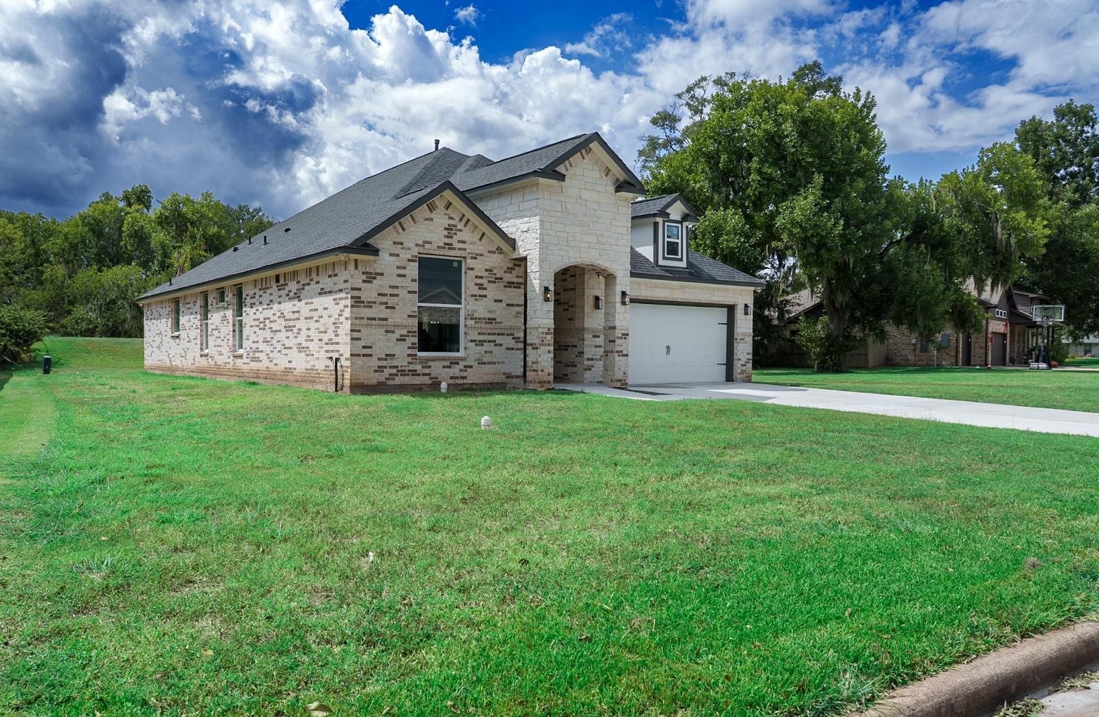 2306 Ridgewood Drive Drive, West Columbia, TX 77486 A brick home with a spacious two-car garage, set on a lush, expansive lawn in a serene neighborhood.