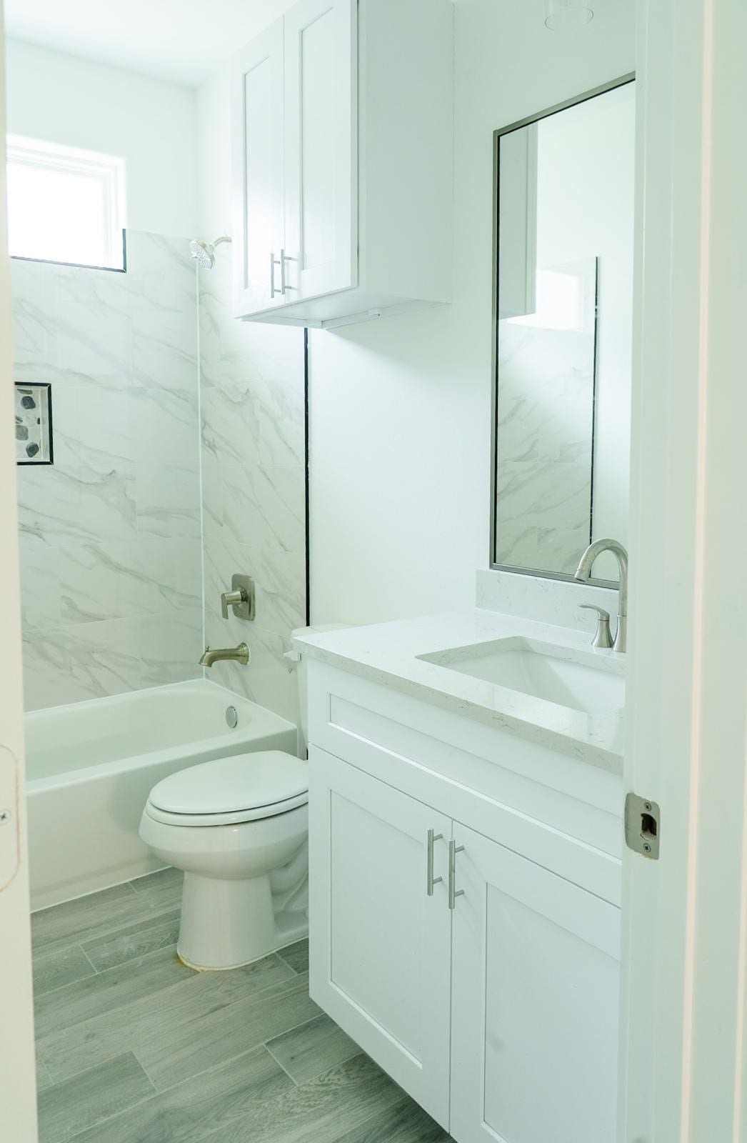 2306 Ridgewood Drive Drive, West Columbia, TX 77486 Bright and modern bathroom featuring a sleek vanity, marble tile accents, and a clean, airy design.