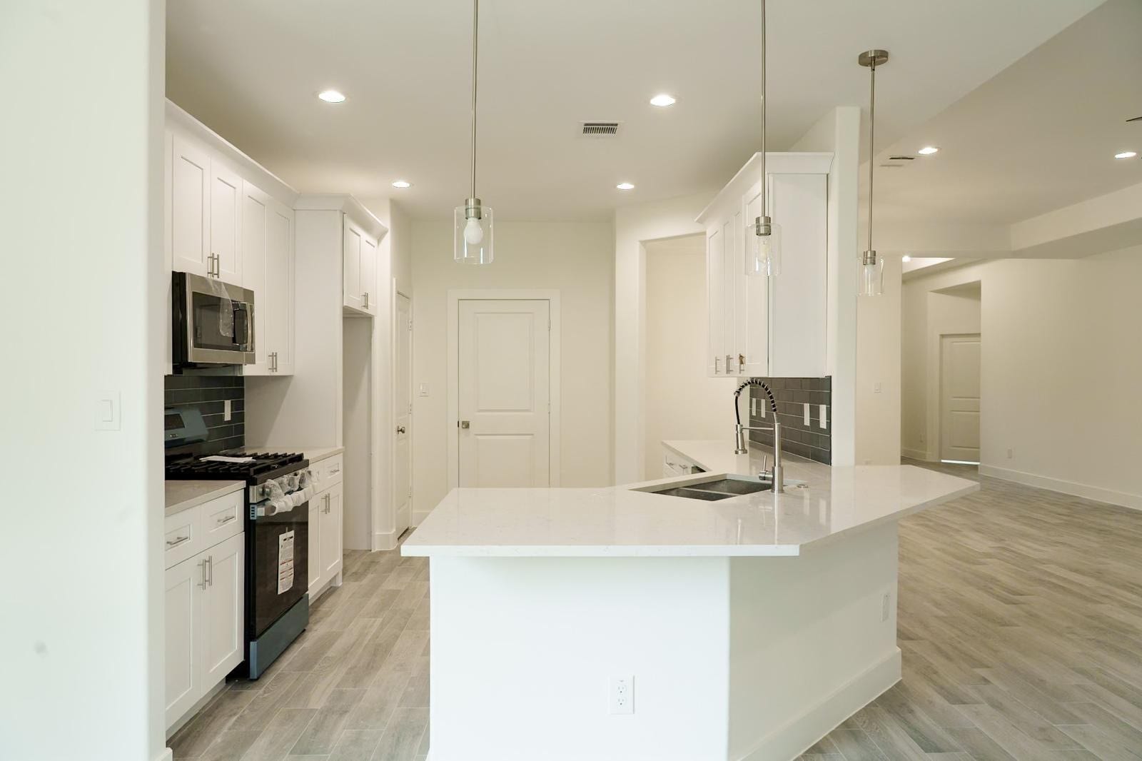 2306 Ridgewood Drive Drive, West Columbia, TX 77486 Bright, modern kitchen with sleek white cabinetry, stainless steel appliances, and a spacious island perfect for entertaining.