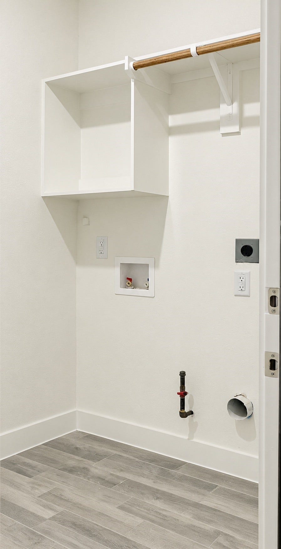 2306 Ridgewood Drive Drive, West Columbia, TX 77486 Bright laundry area with built-in shelving, rod for hanging clothes, and essential hookups for washer and dryer.