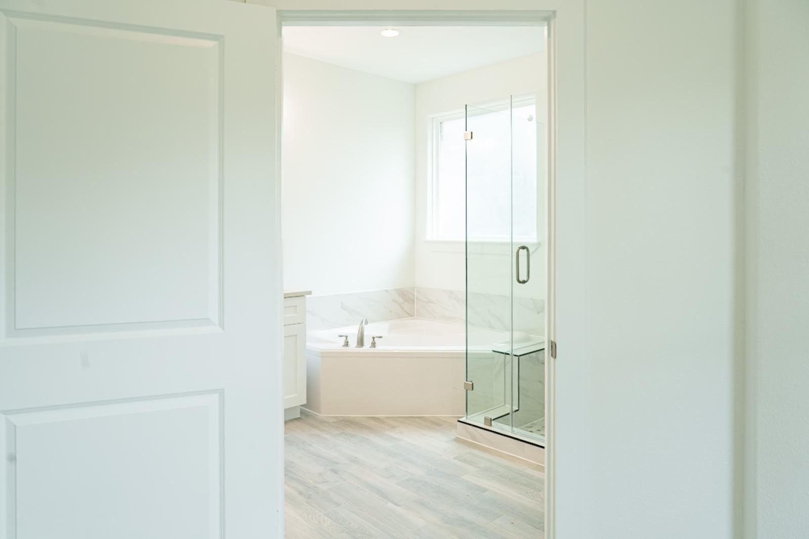 2306 Ridgewood Drive Drive, West Columbia, TX 77486 Bright and inviting bathroom featuring a glass-enclosed shower, a spacious soaking tub, and elegant marble accents.