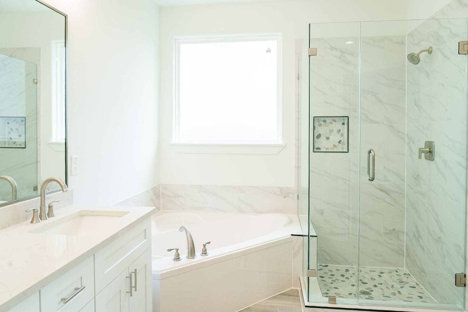 2306 Ridgewood Drive Drive, West Columbia, TX 77486 Bright and modern bathroom featuring a spacious glass-enclosed shower, elegant vanity with sleek fixtures, and a luxurious corner soaking tub.