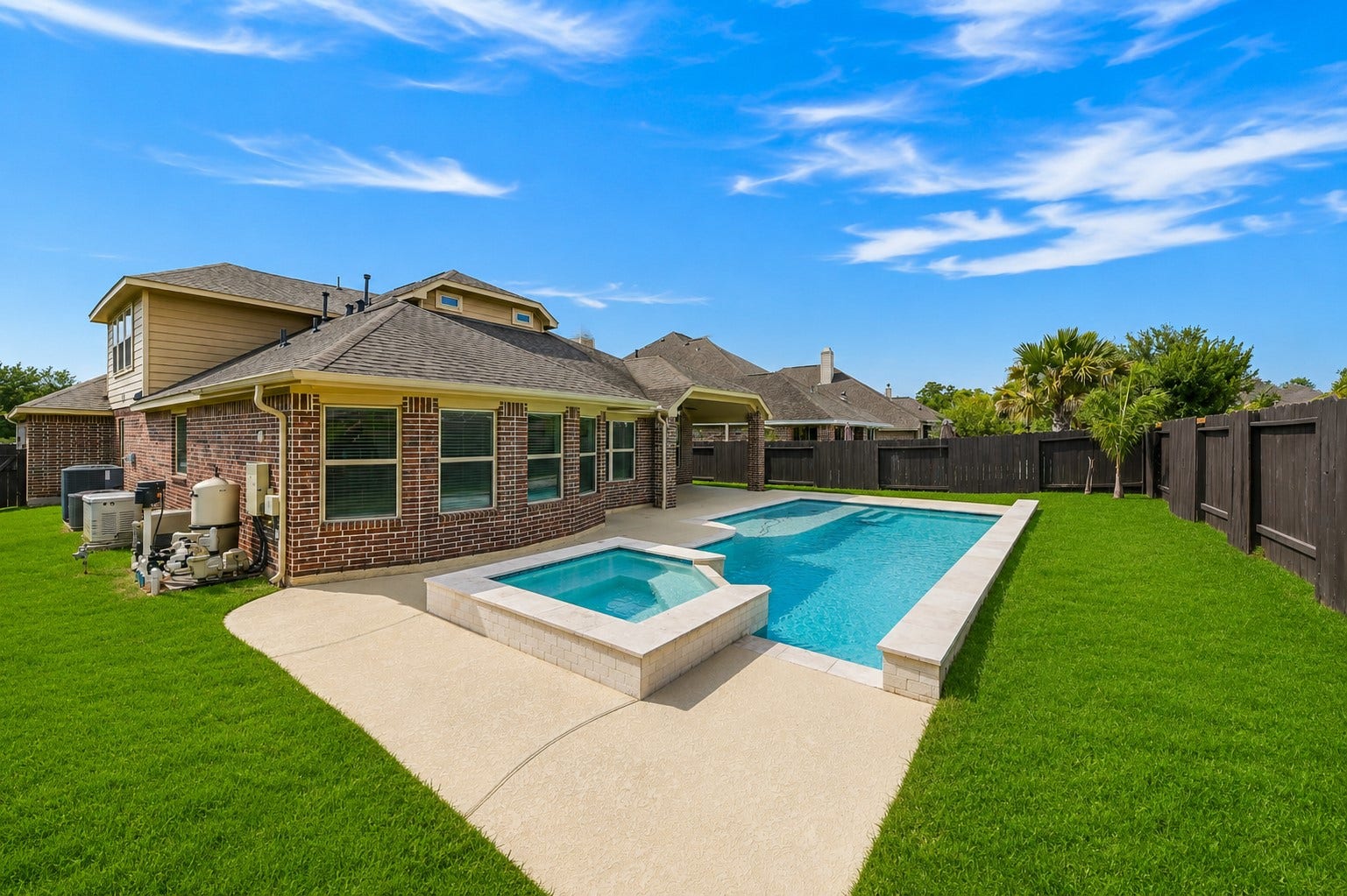 16718 Lake Limestone Ln with its expansive backyard, a sparkling pool, and attached spa, surrounded by plenty of deck space for lounging and entertaining.