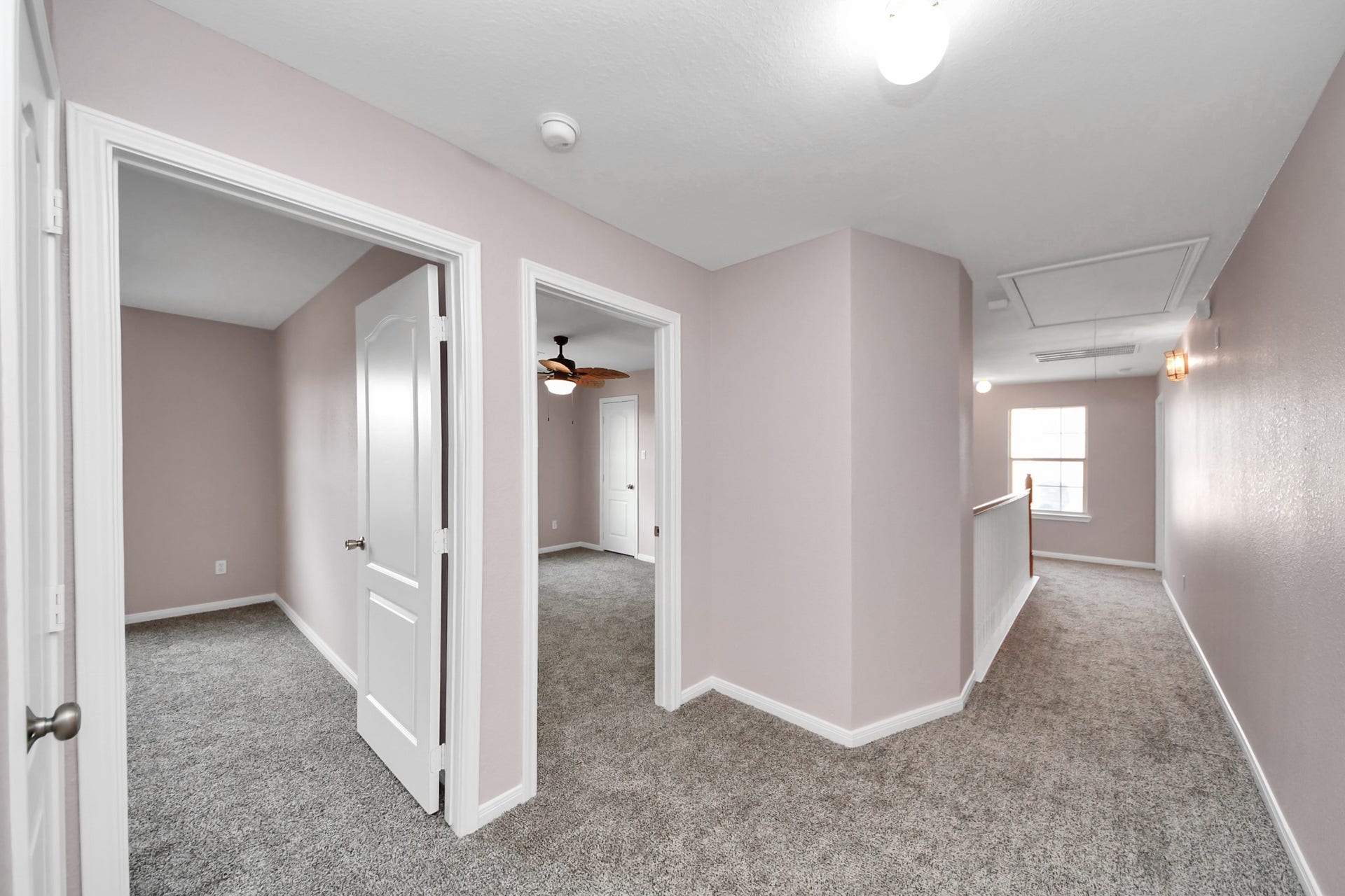 10026 Gil Jr Lane, Houston, TX 77075 Spacious upper hallway with plush carpeting and access to multiple rooms, featuring a ceiling fan and abundant natural light.