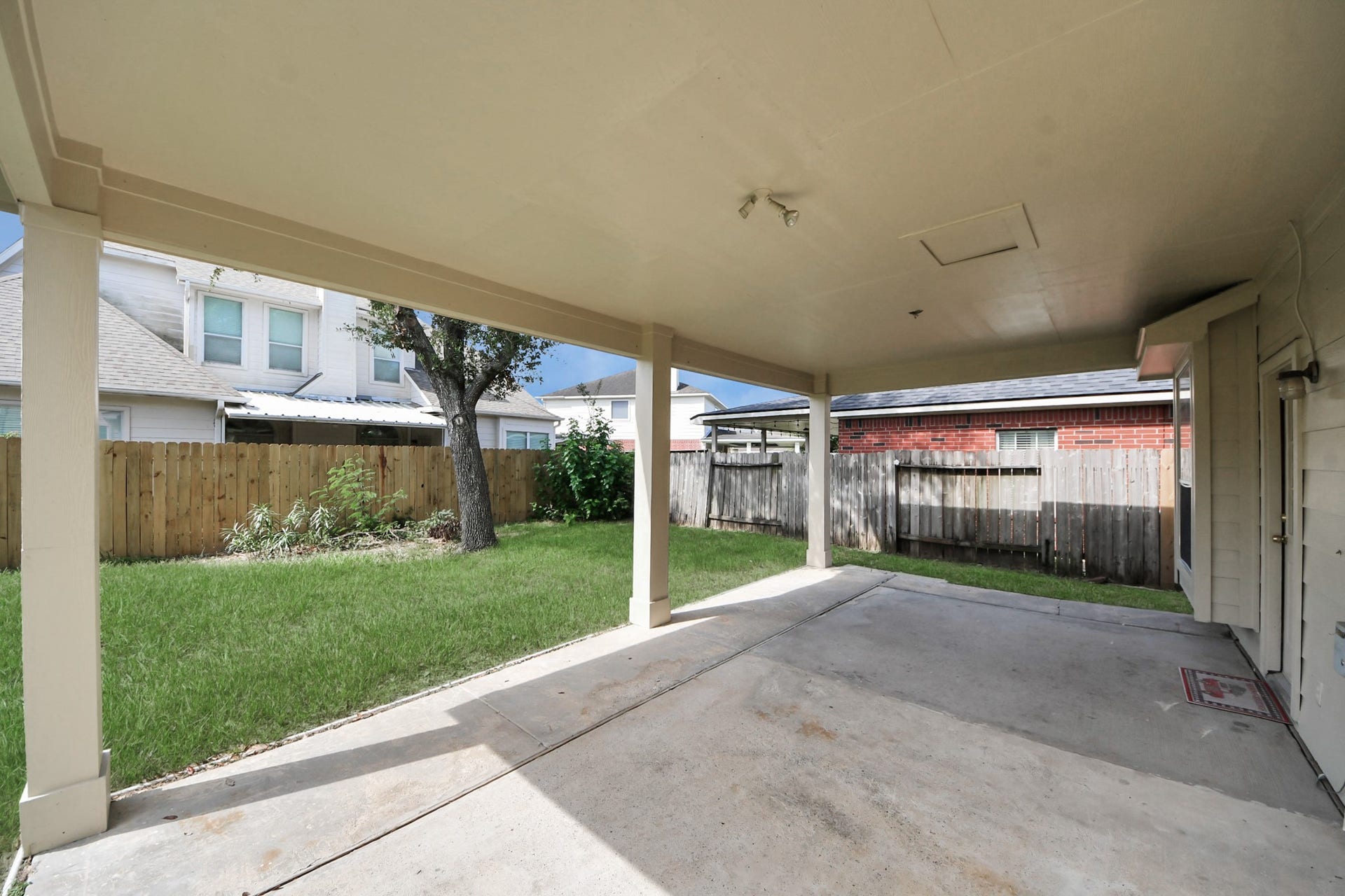 10026 Gil Jr Lane, Houston, TX 77075 Spacious covered patio overlooking a lush green backyard, perfect for outdoor relaxation and entertainment.