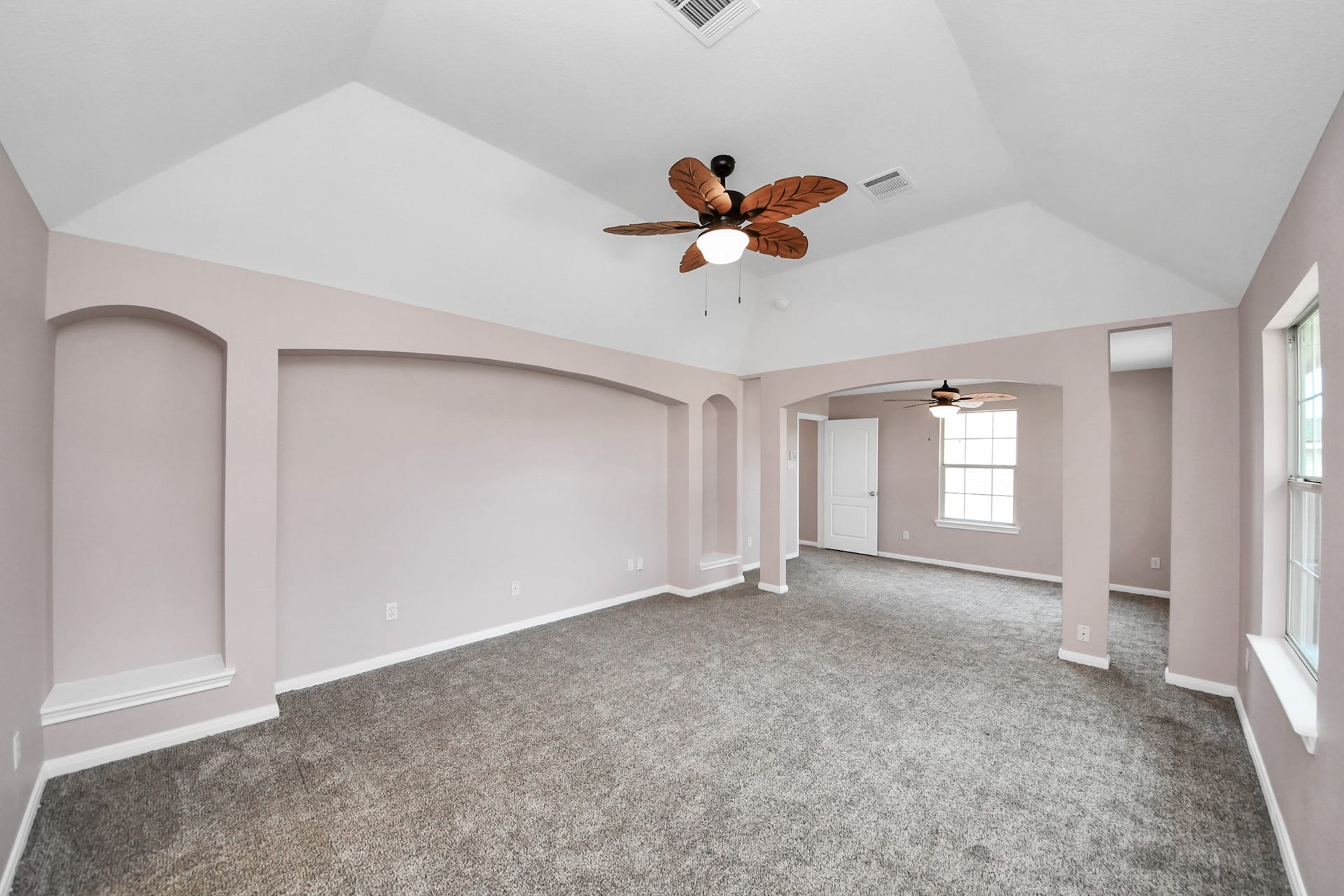 10026 Gil Jr Lane, Houston, TX 77075 Experience the spacious elegance of this primary suite, featuring vaulted ceilings, soft carpeting, and abundant natural light, creating a perfect retreat.