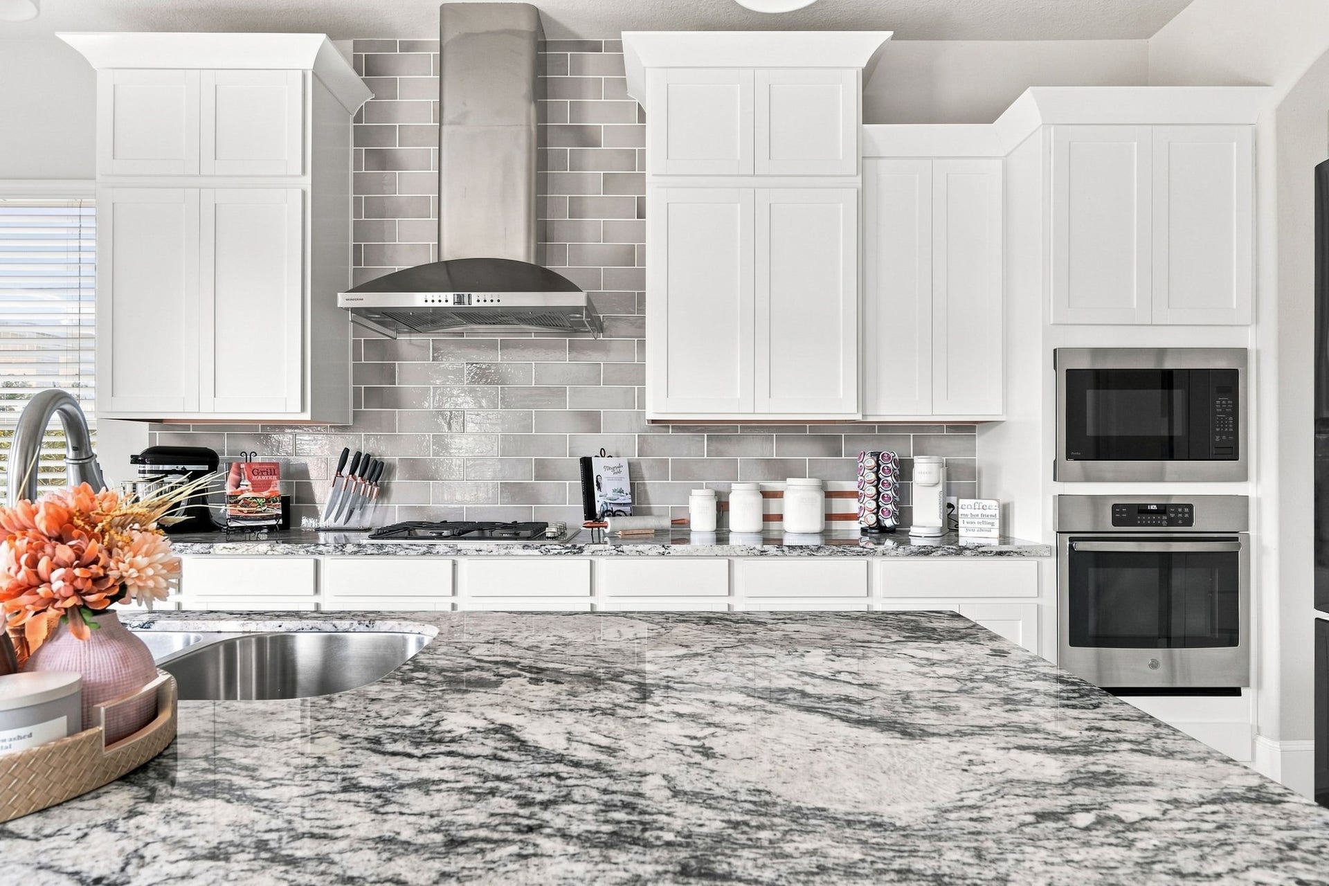 30719 Barred Owl Way, Fulshear, TX 77423 A gas cooktop, stainless-steel vent hood, and built-in appliances create a beautifully equipped cooking space.