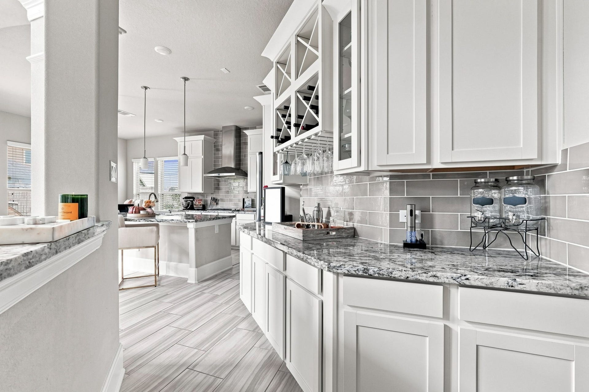 30719 Barred Owl Way, Fulshear, TX 77423 The striking granite countertops provide a beautiful contrast to the white cabinetry and gray tile backsplash.