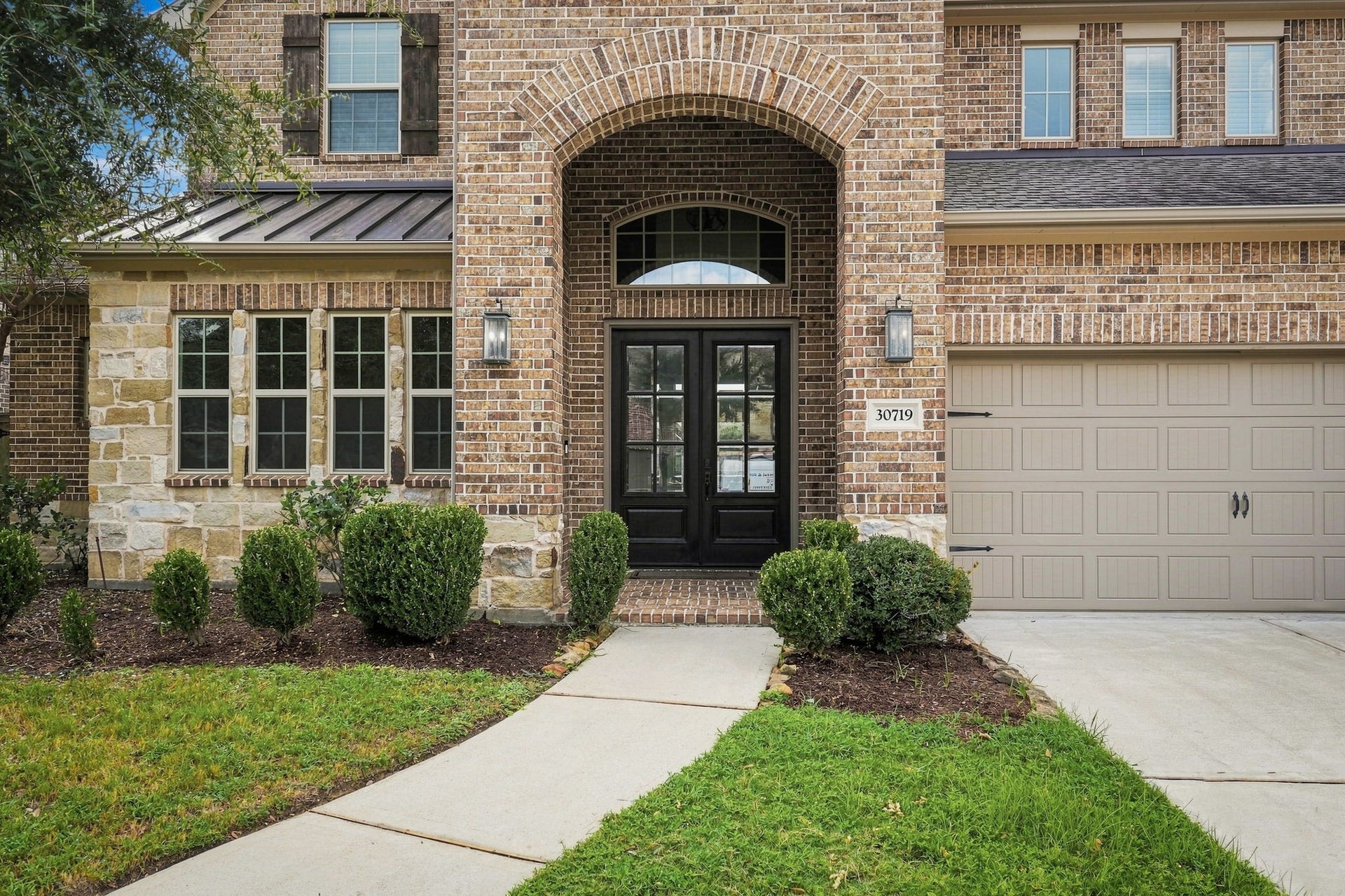 30719 Barred Owl Way, Fulshear, TX 77423 Elegant double front doors and exterior lighting add to the homes distinguished curb appeal.