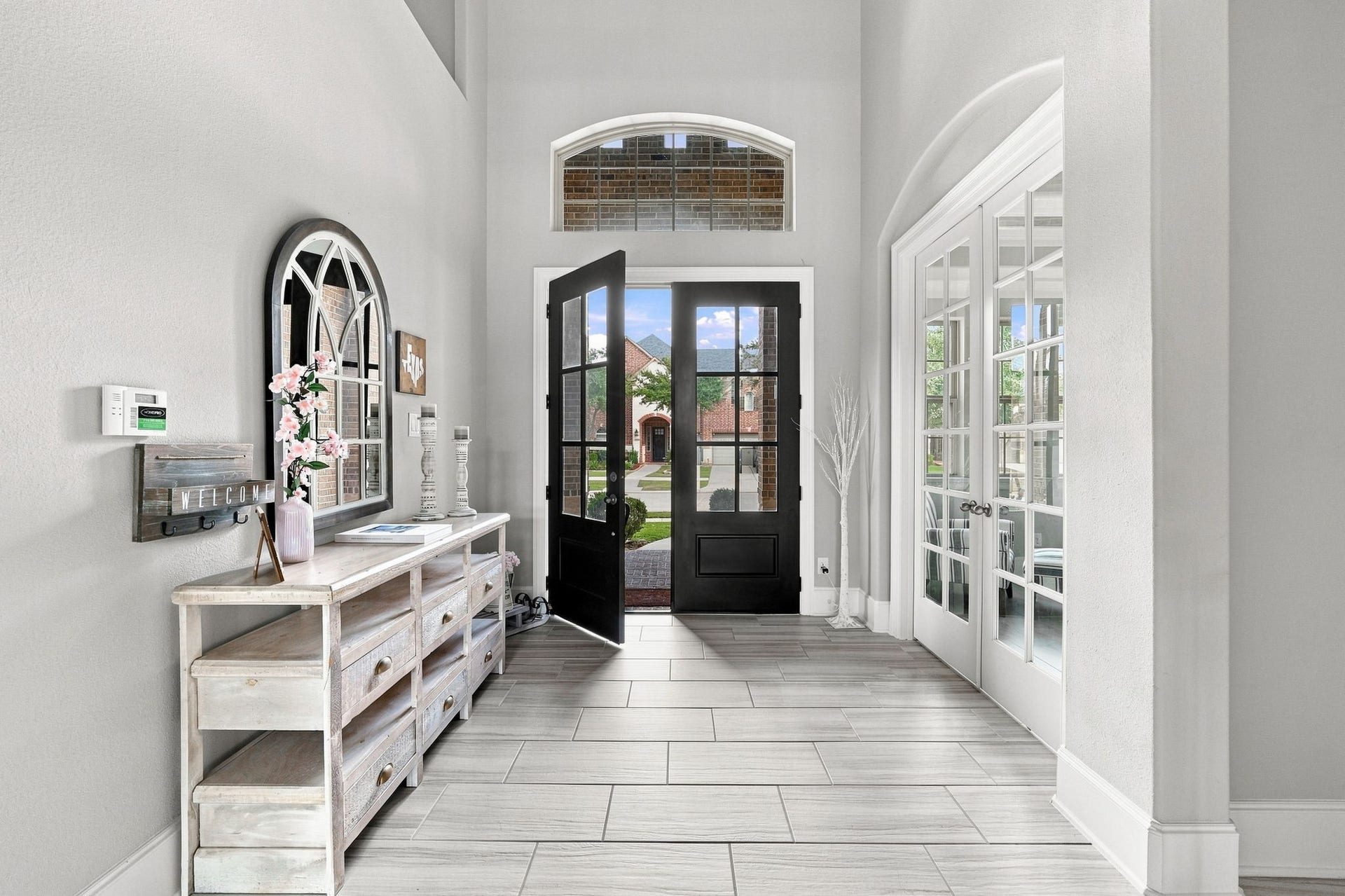 30719 Barred Owl Way, Fulshear, TX 77423 Beautiful tile flooring, graceful archways, and striking black railing accents add depth and sophistication.