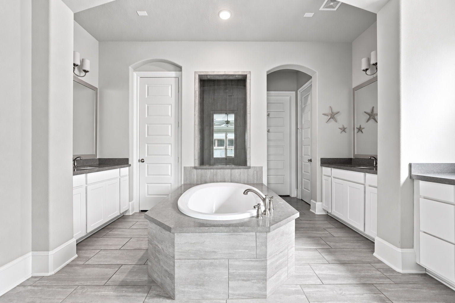 30719 Barred Owl Way, Fulshear, TX 77423 The spectacular primary bathroom is designed around a beautiful soaking tub with an elegant tiled surround.