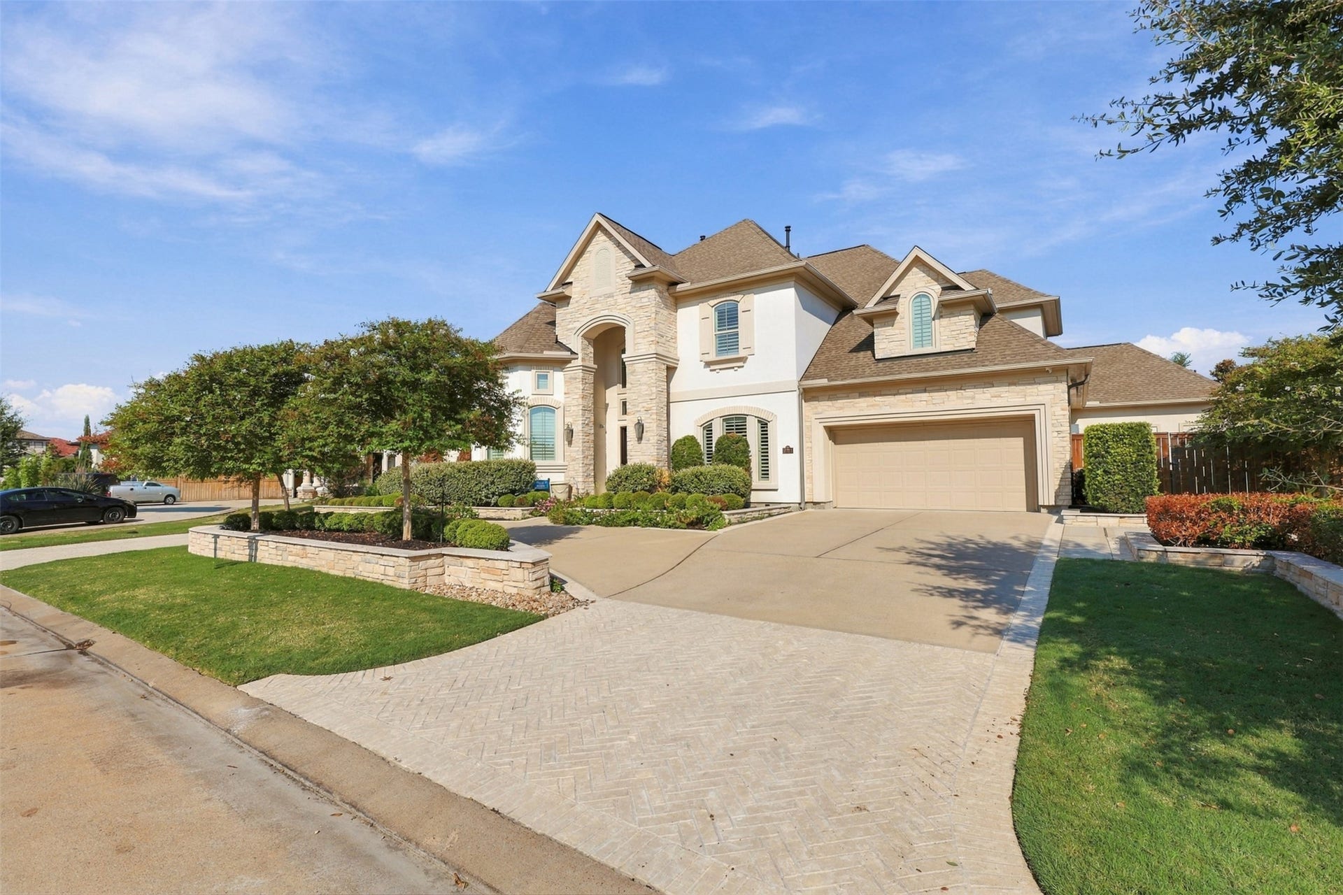 10311 Joshua Creek Court, Cypress, TX 77433 Beautiful two-story home featuring stone accents, elegant architecture, and professionally landscaped front yard.