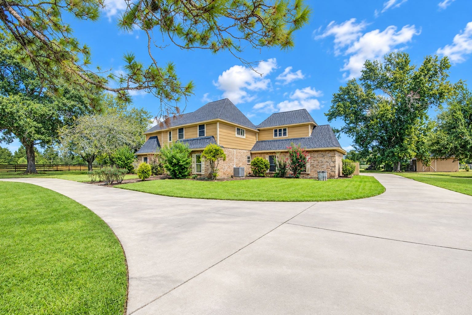 This charming two-story home sits back on a circular driveway behind beautiful mature pine trees.