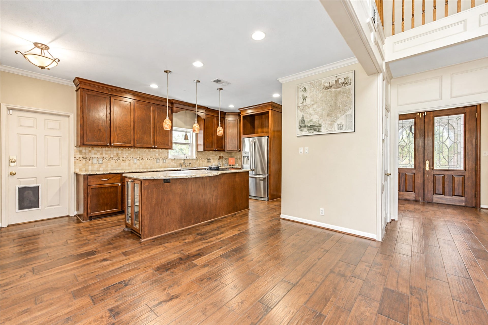 This spacious kitchen with elegant solid wooden cabinetry, granite countertops, and modern stainless steel appliances, seamlessly connects to the inviting living room.