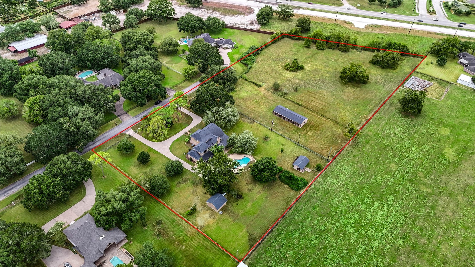 This expansive 5.5acre+ property with lush greenery, features a spacious home, inviting pool, and ample land for outdoor activities, a horse barn and more!