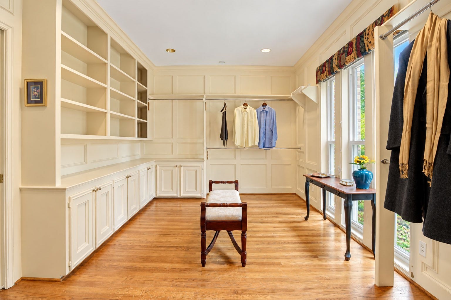 The large primary closet features natural light and beautiful built-in cabinetry.