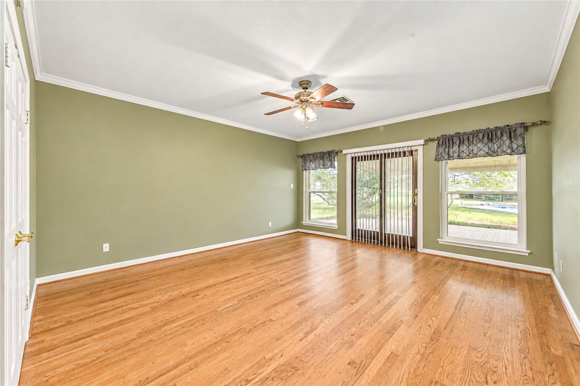 The primary bedroom has large windows that offer abundant natural light and views of the backyard.