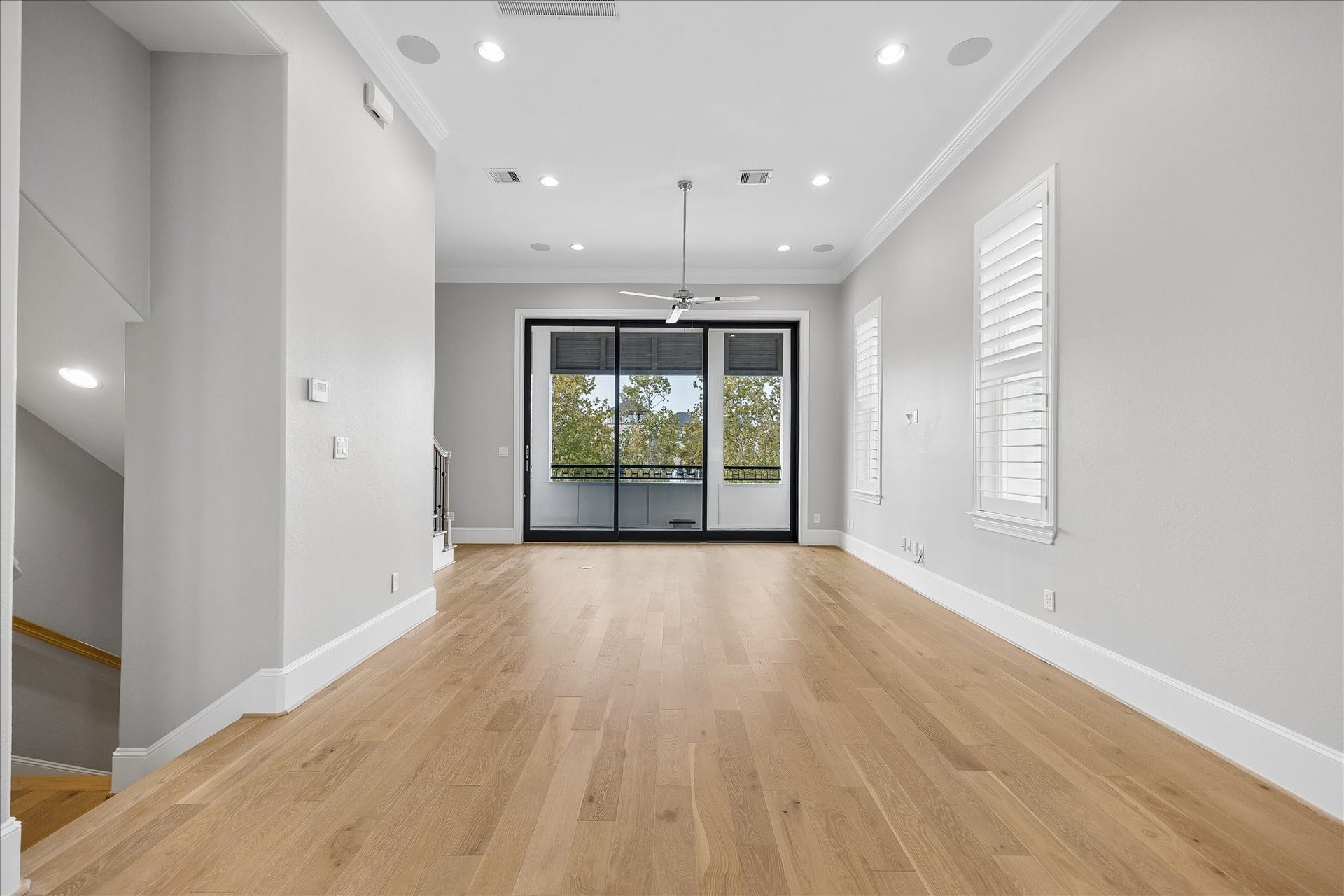 6029 Matthew Oaks Place, Houston, TX 77007 Spacious living area with elegant hardwood floors, abundant natural light, and a modern ceiling fan, leading to a large window with a scenic Lake views. This is a gourgeous picture of what you view everyday.