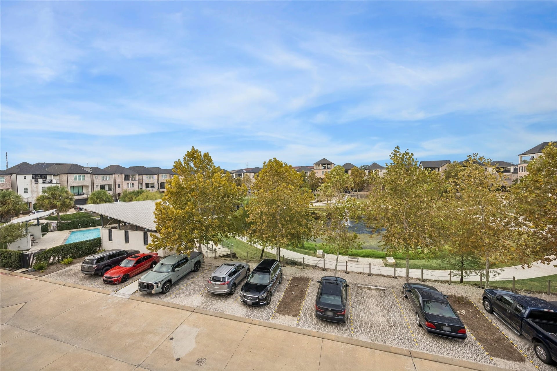 6029 Matthew Oaks Place, Houston, TX 77007 Enjoy serene views of a landscaped pond and community pool, surrounded by charming townhouses and ample parking.