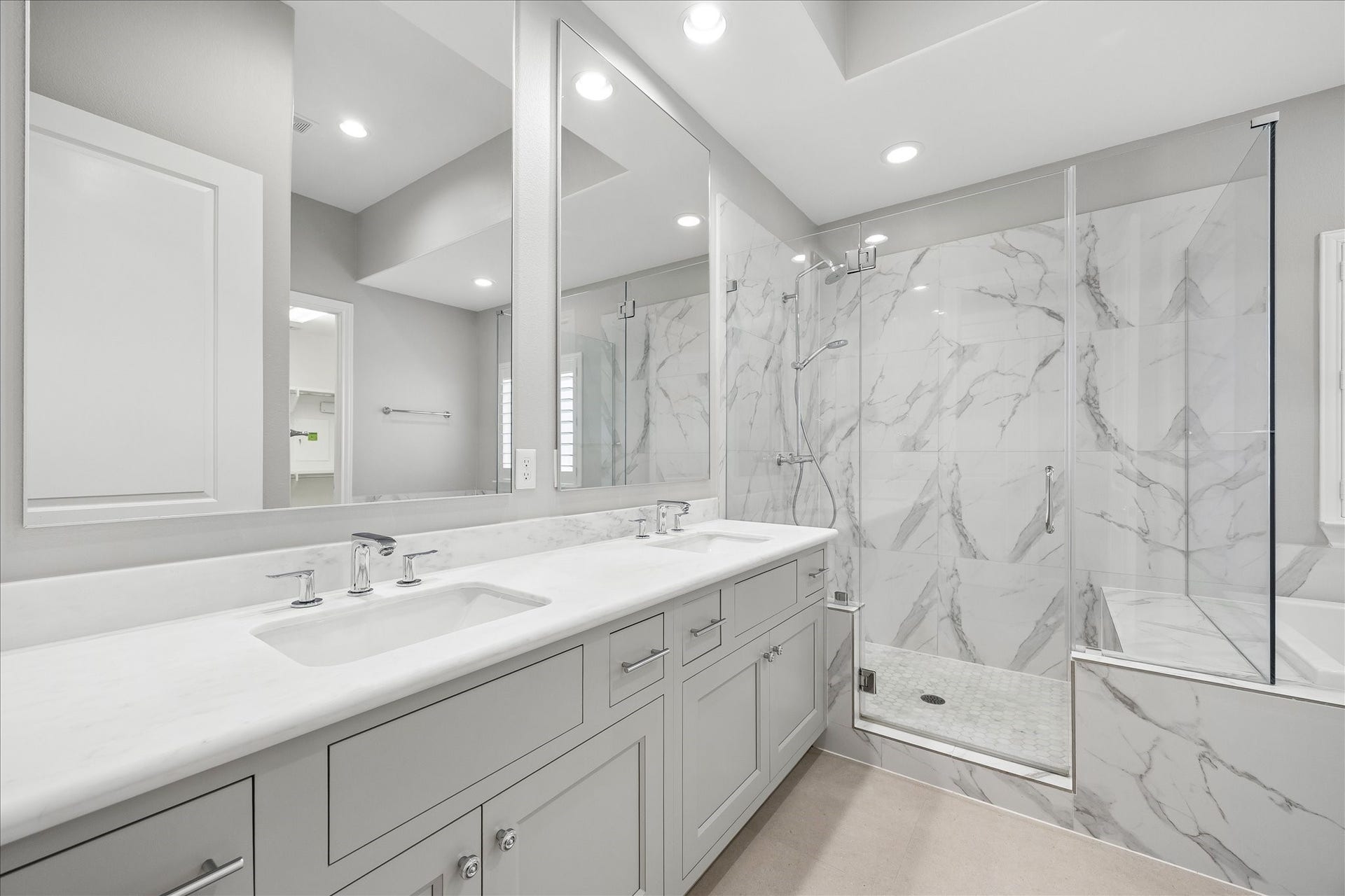 6029 Matthew Oaks Place, Houston, TX 77007 Elegant bathroom featuring a spacious double vanity with modern fixtures, a sleek glass-enclosed shower, and luxurious marble tile accents.