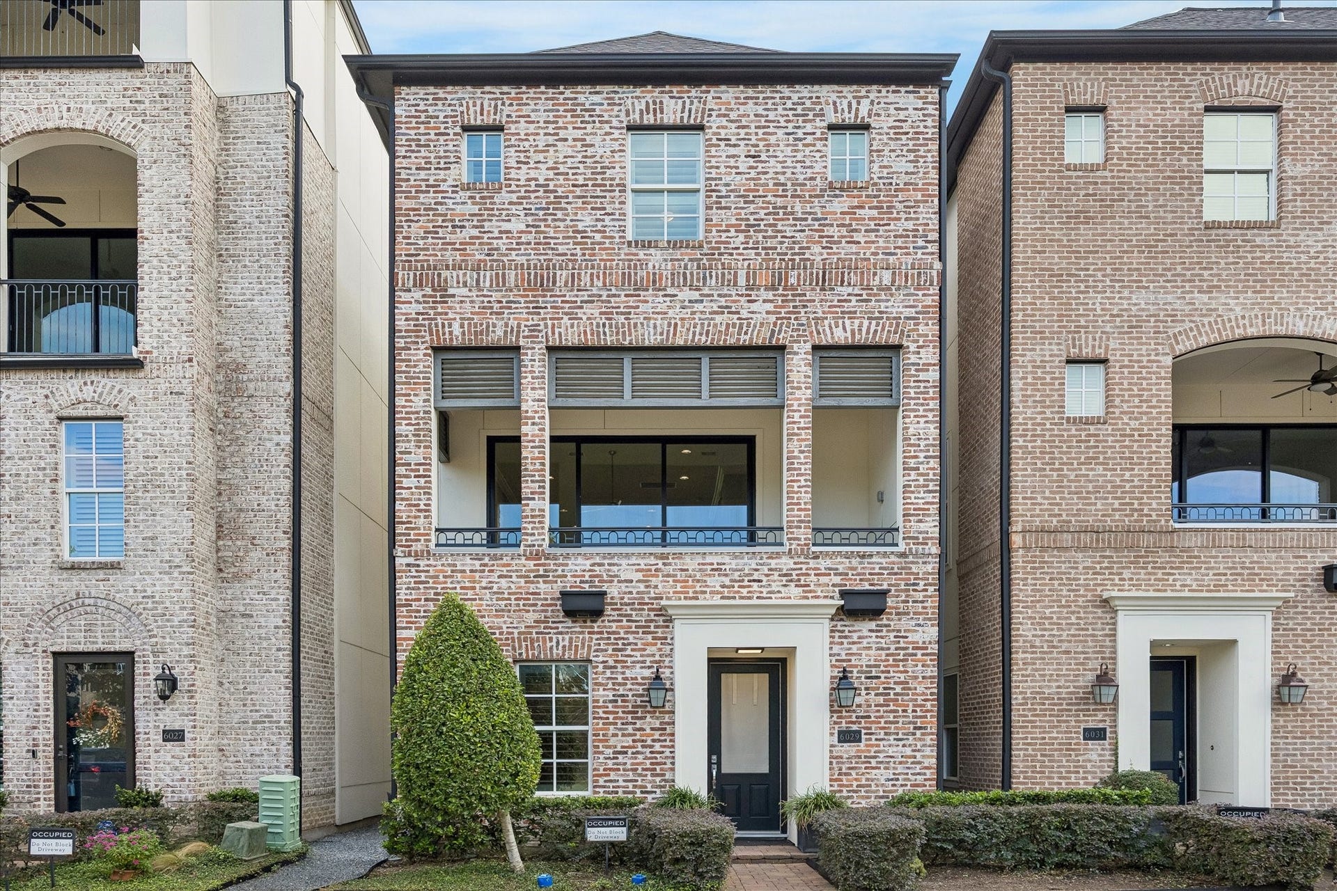 6029 Matthew Oaks Place, Houston, TX 77007 Elegant three-story single family home with classic brick facade and inviting balcony overlooking the community Lake and fountain for outdoor comfort and enjoyment.