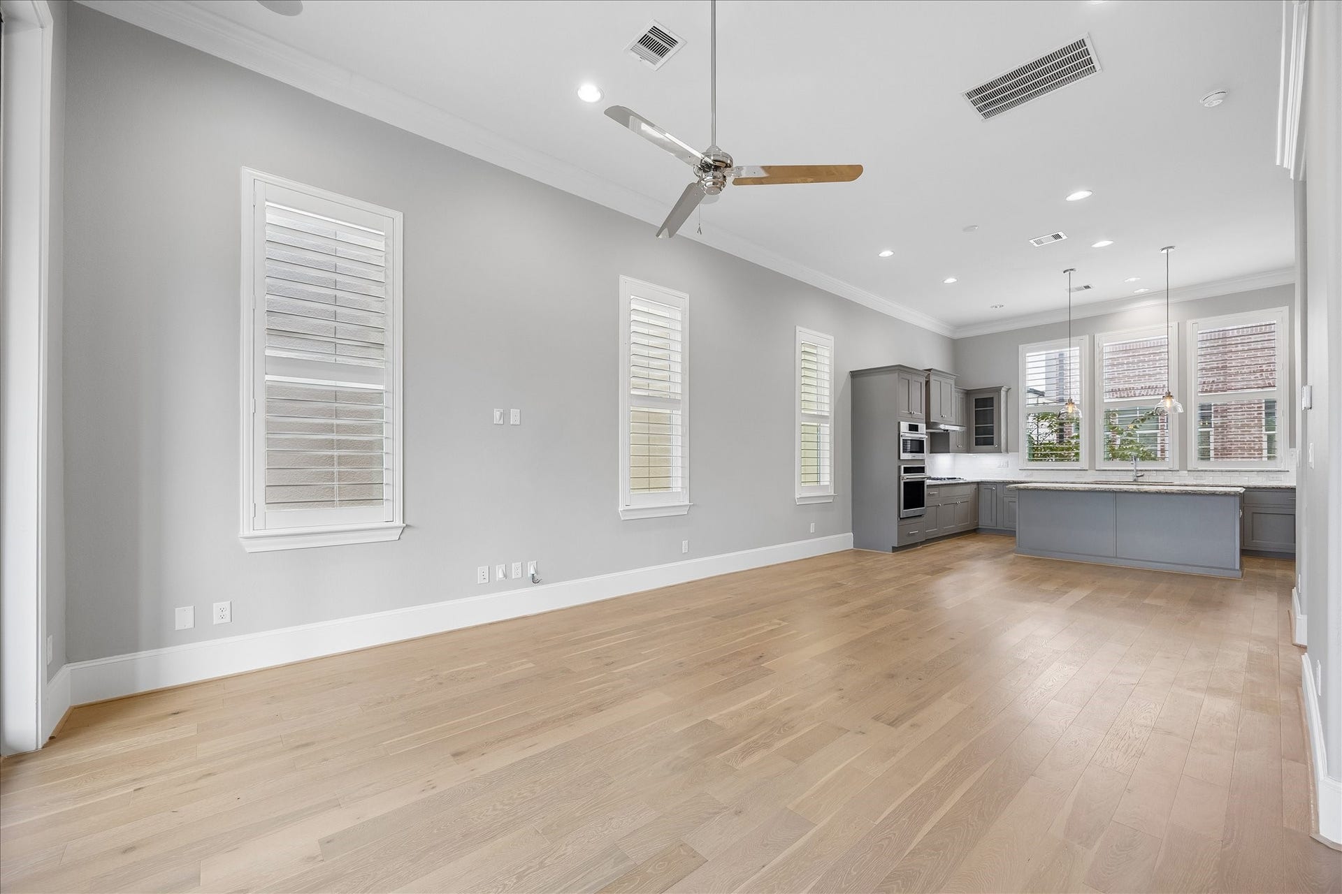 6029 Matthew Oaks Place, Houston, TX 77007 Spacious open-concept living area with beautiful hardwood floors, modern kitchen featuring granite countertops, and abundant natural light from large windows.