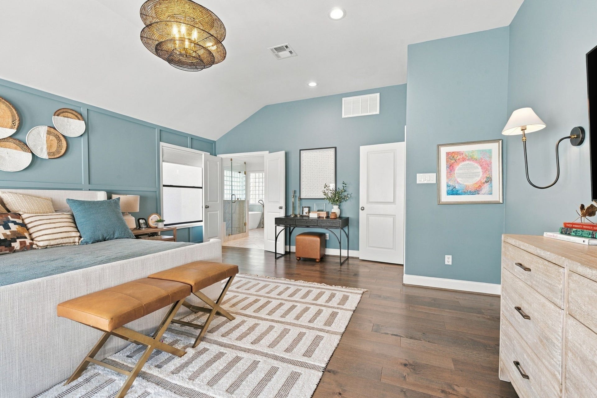 The primary suite offers a wonderful layout w/vaulted ceiling, hardwood floors & beautiful designer finishes. A versatile space for a desk or vanity leads to the ensuite bath, completing this impressive primary retreat.