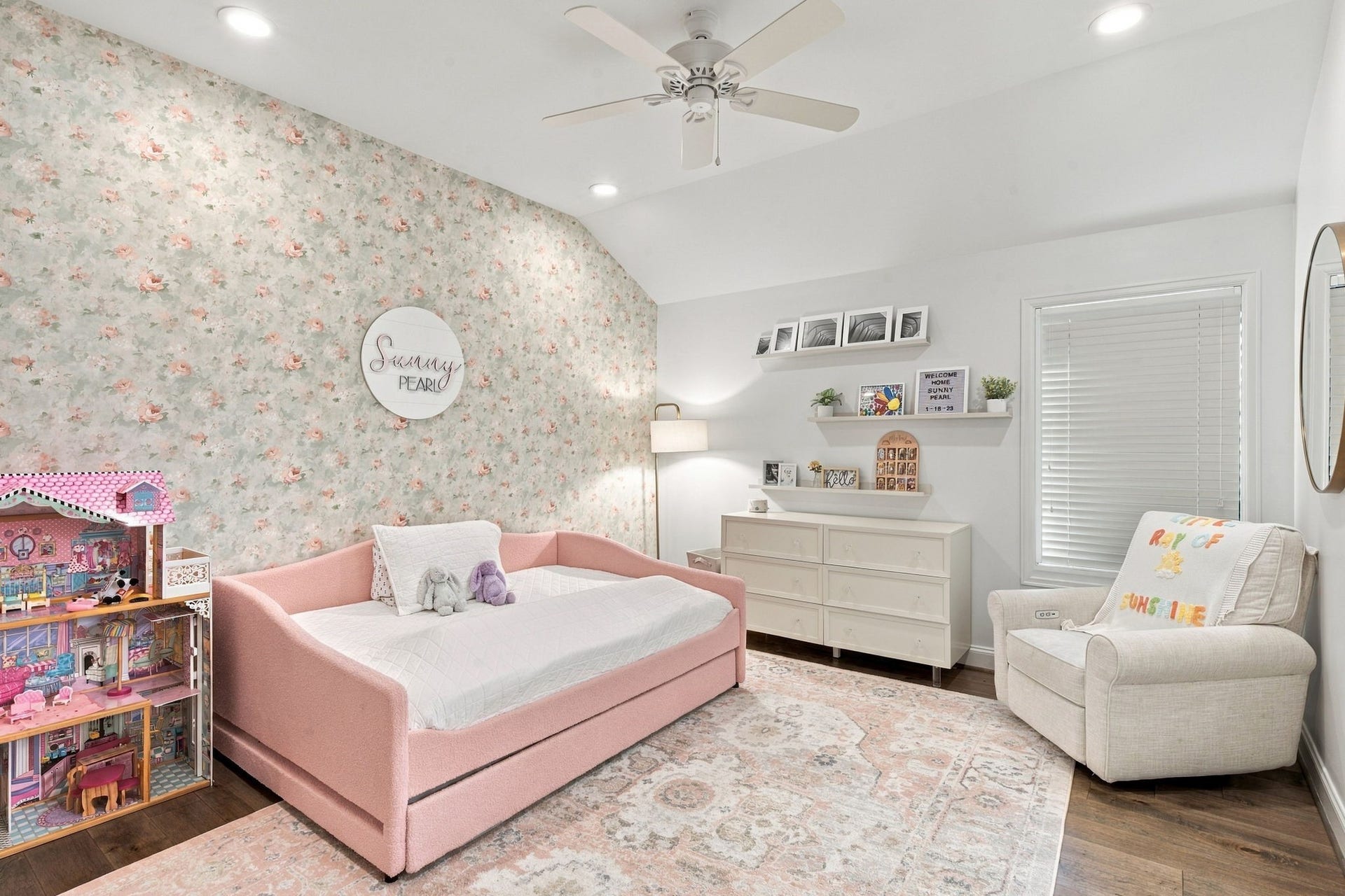 Another view at this inviting secondary bedroom showcasing hardwood floors, vaulted ceiling, recessed lighting & a beautiful floral accent wall. Room offers space for bedroom furnishings, a reading area & additional storage.