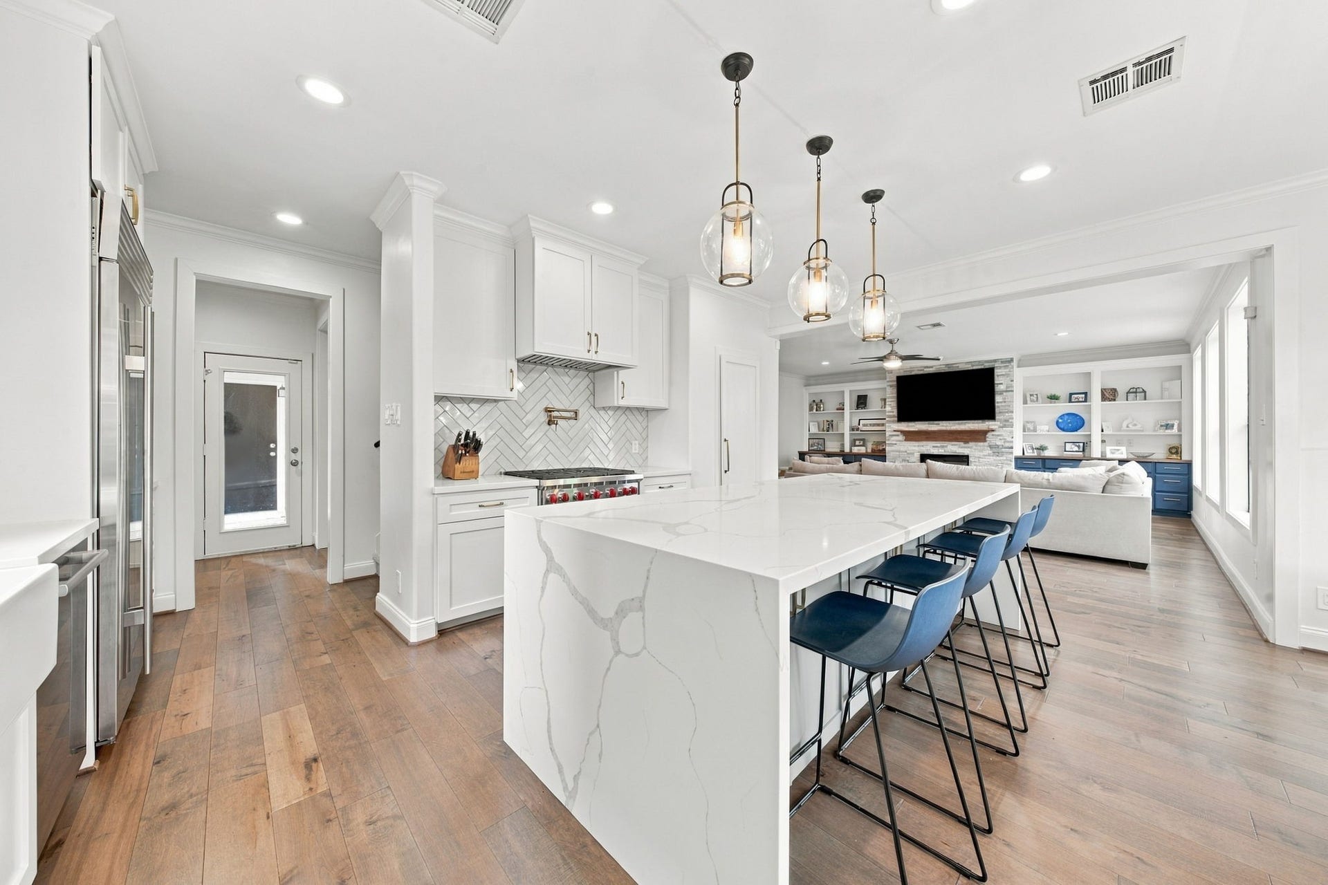 Beautifully designed kitchen opens seamlessly to the spacious living room, creating an exceptional layout for entertaining & everyday living. The oversized waterfall island anchors the space, while the gas range w/pot filler, custom cabinetry & nearby access to the mudroom & secondary staircase add convenience & functionality.