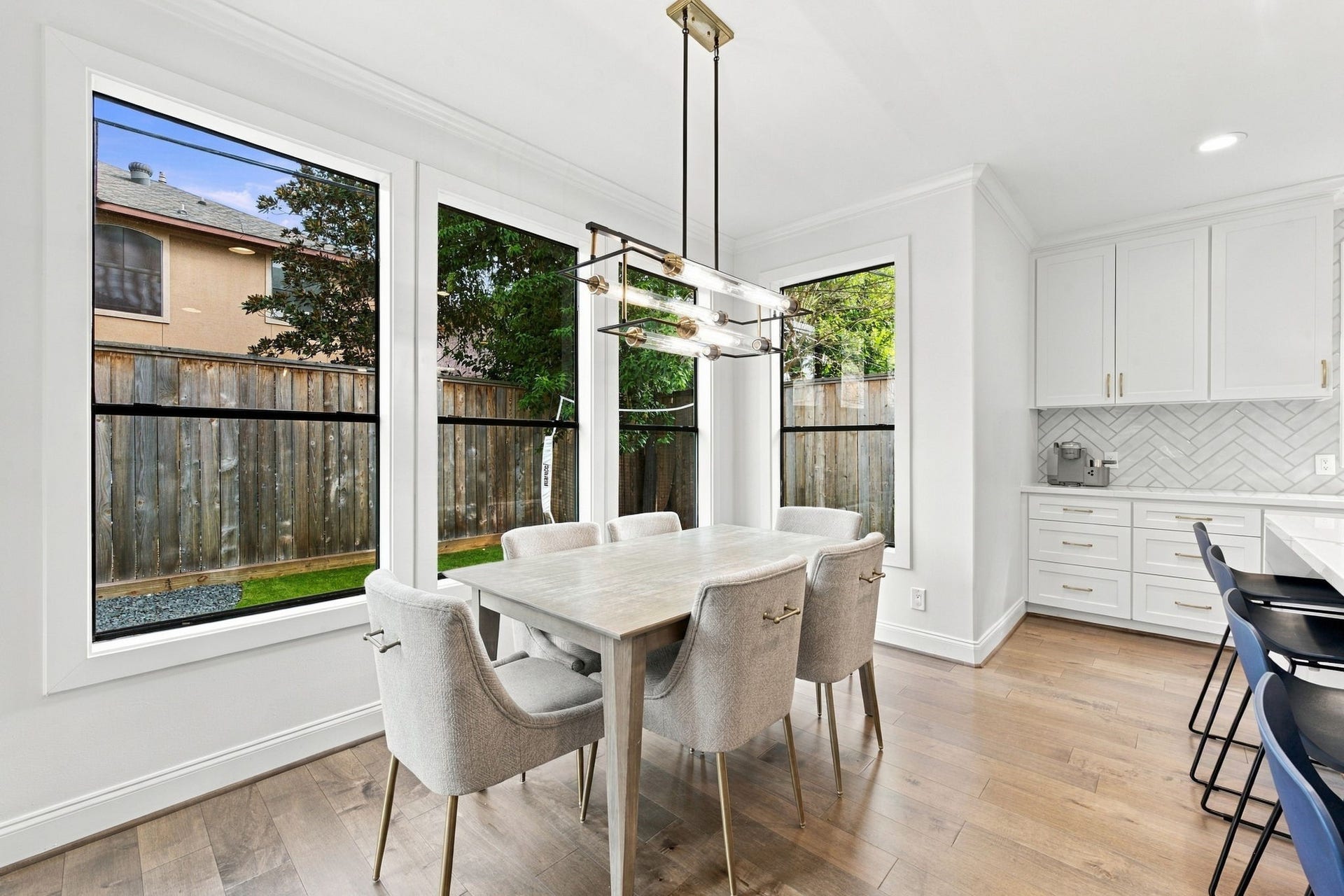 Bright & inviting breakfast area adjoining the kitchen features beautiful hardwood floors, expansive windows overlooking the backyard & a striking modern linear chandelier. Surrounded by natural light, this wonderful dining space offers a lovely setting for casual meals while remaining conveniently connected to the kitchen & oversized island.