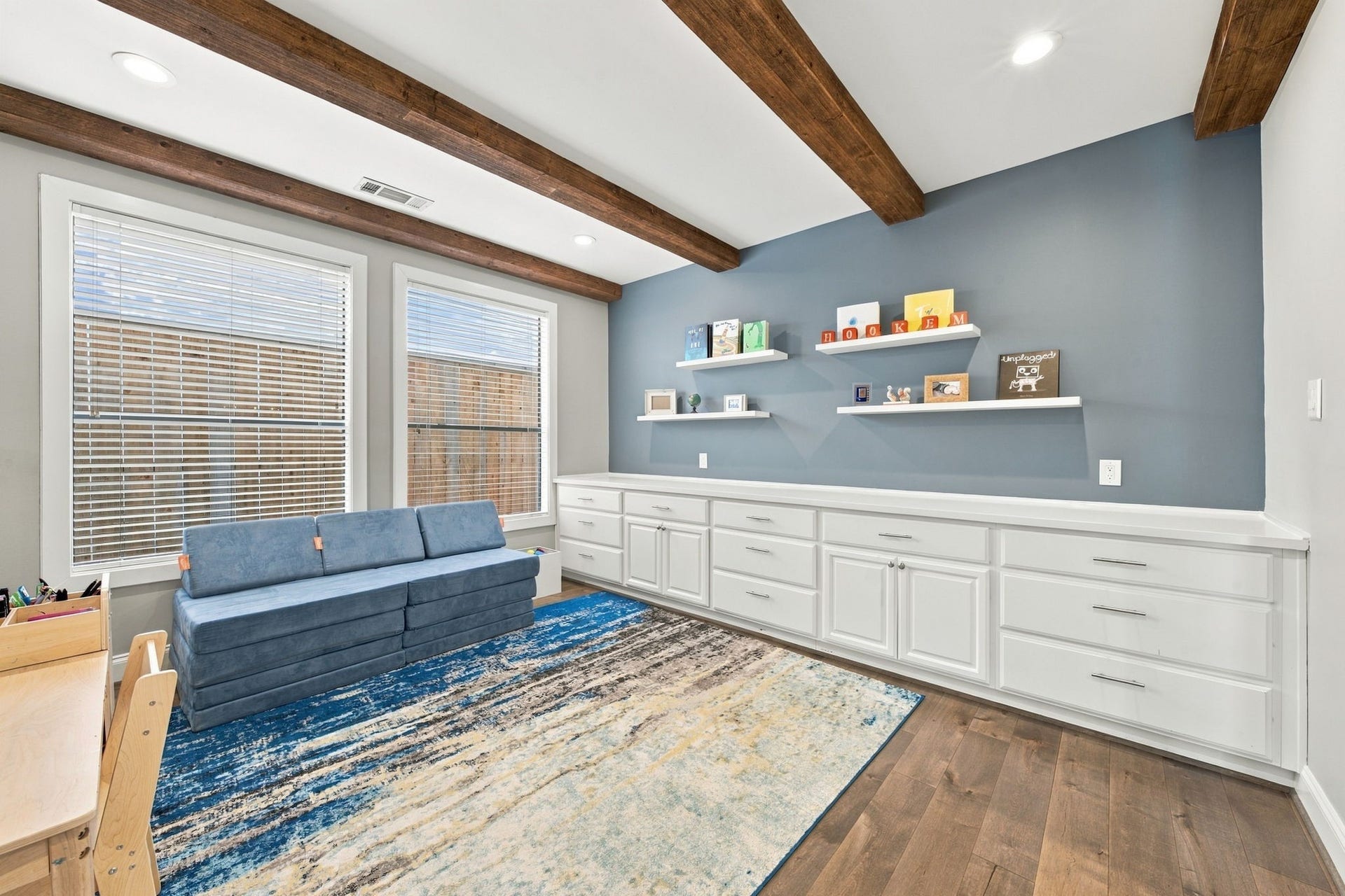 A closer look showcases the striking blue accent wall, extensive built-in cabinetry w/drawers & cabinets for storage, plus floating display shelves. A wonderful space that can easily accommodate a variety of needs.
