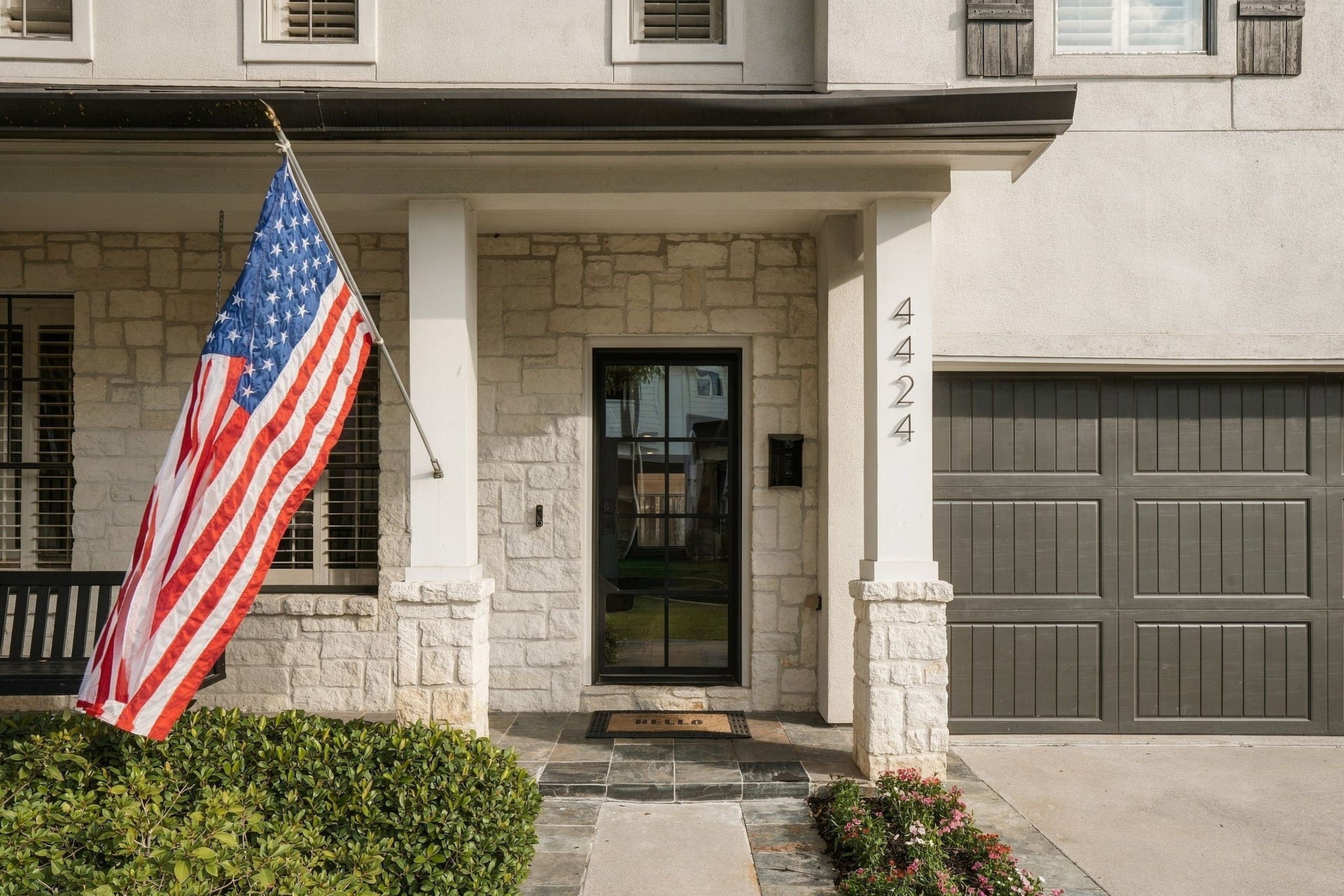 Welcoming covered front porch showcases beautiful natural stonework, substantial columns w/stone accents, slate tile flooring & a striking black-framed glass entry door. Thoughtful architectural details & attractive landscaping create an inviting entrance to this Bellaire home.