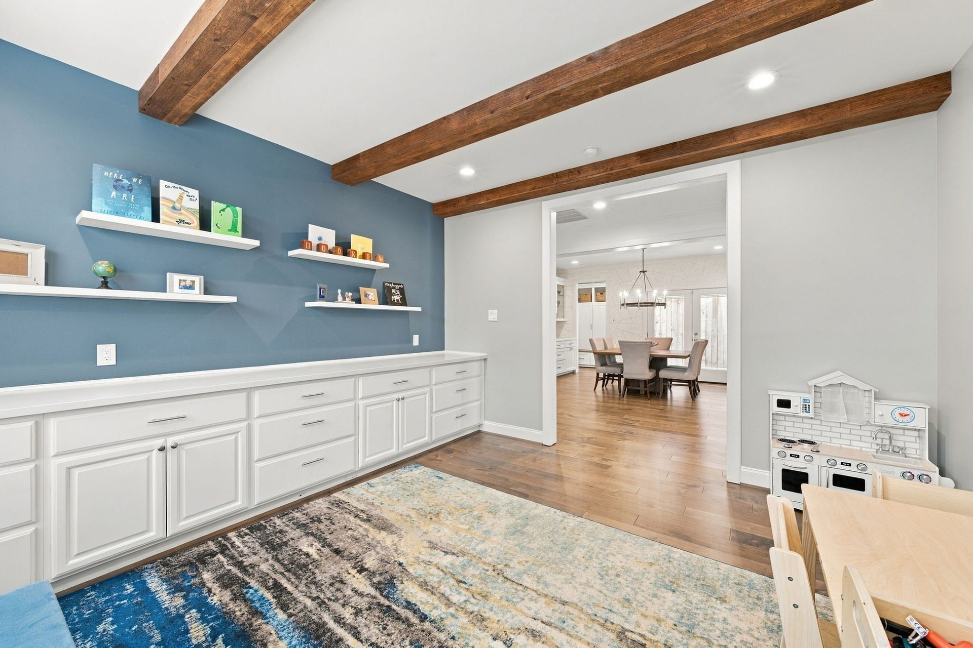 This flexible room opens to the dining area, creating a convenient connection to the home's main living spaces. Beautiful wood ceiling beams continue throughout, adding warmth & architectural character to this thoughtfully designed room.