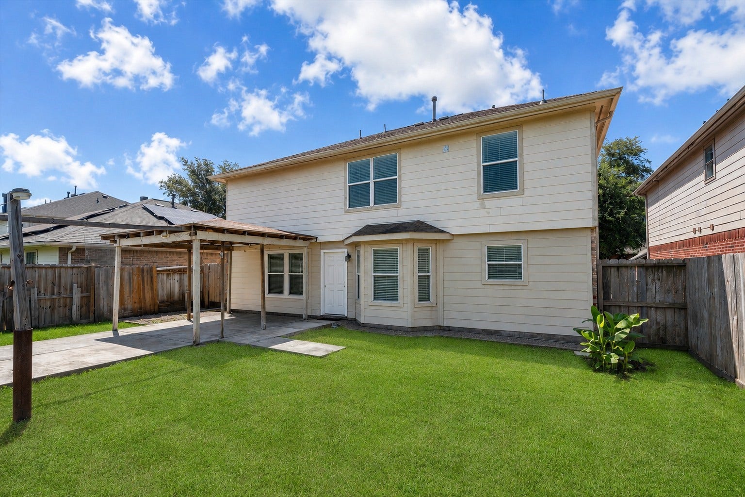 5918 Stirring Winds Lane, Houston, TX 77086 Spacious backyard featuring a covered patio, open green space, and room for outdoor entertaining, play, gardening, or pets.